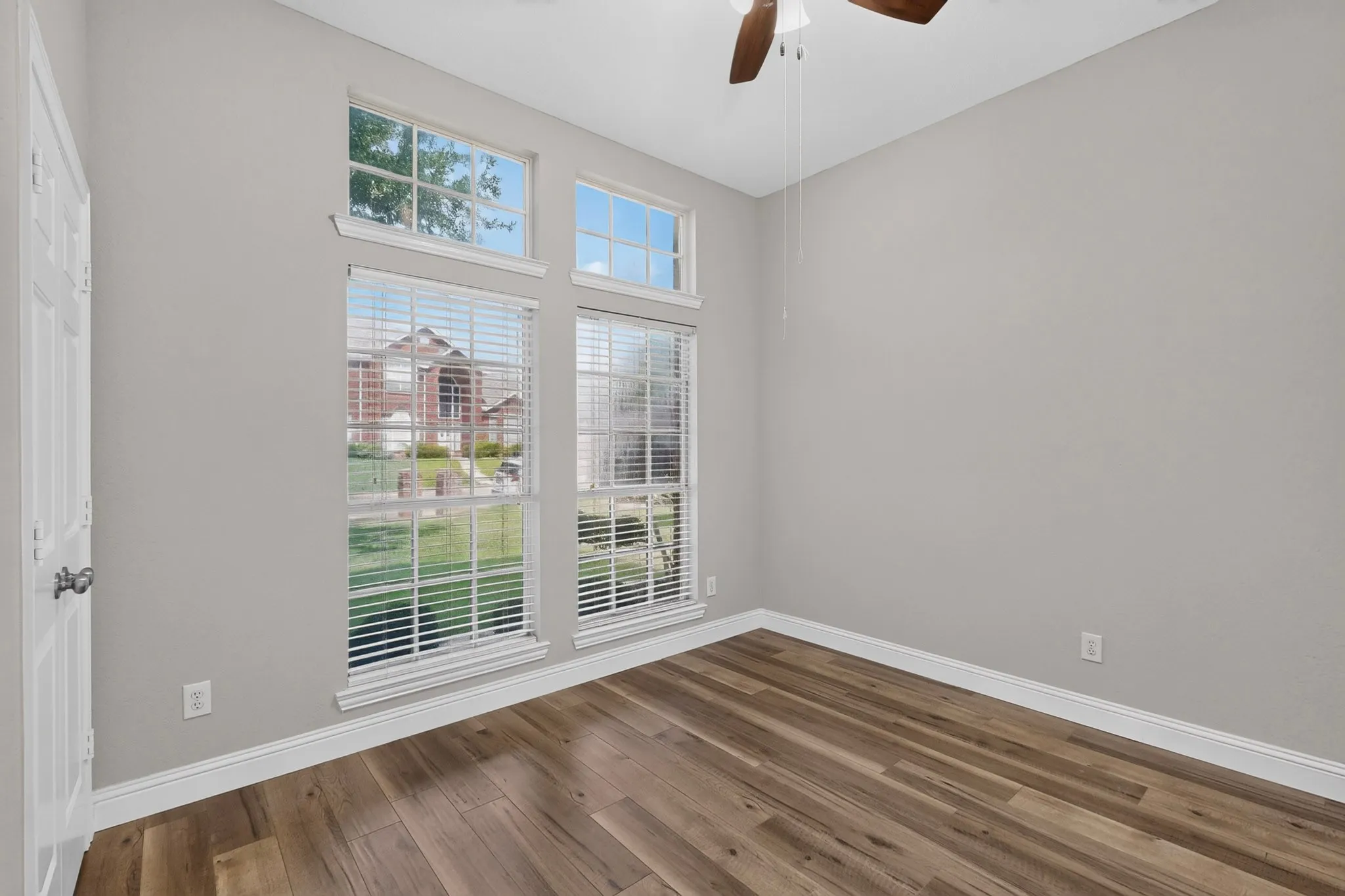 Room featuring wood-finish flooring, white baseboards, and neutral wall paint