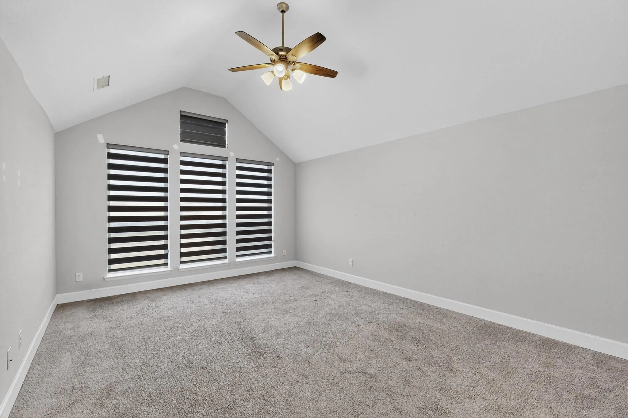 Bonus room featuring vaulted ceiling, light carpet, and a ceiling fan