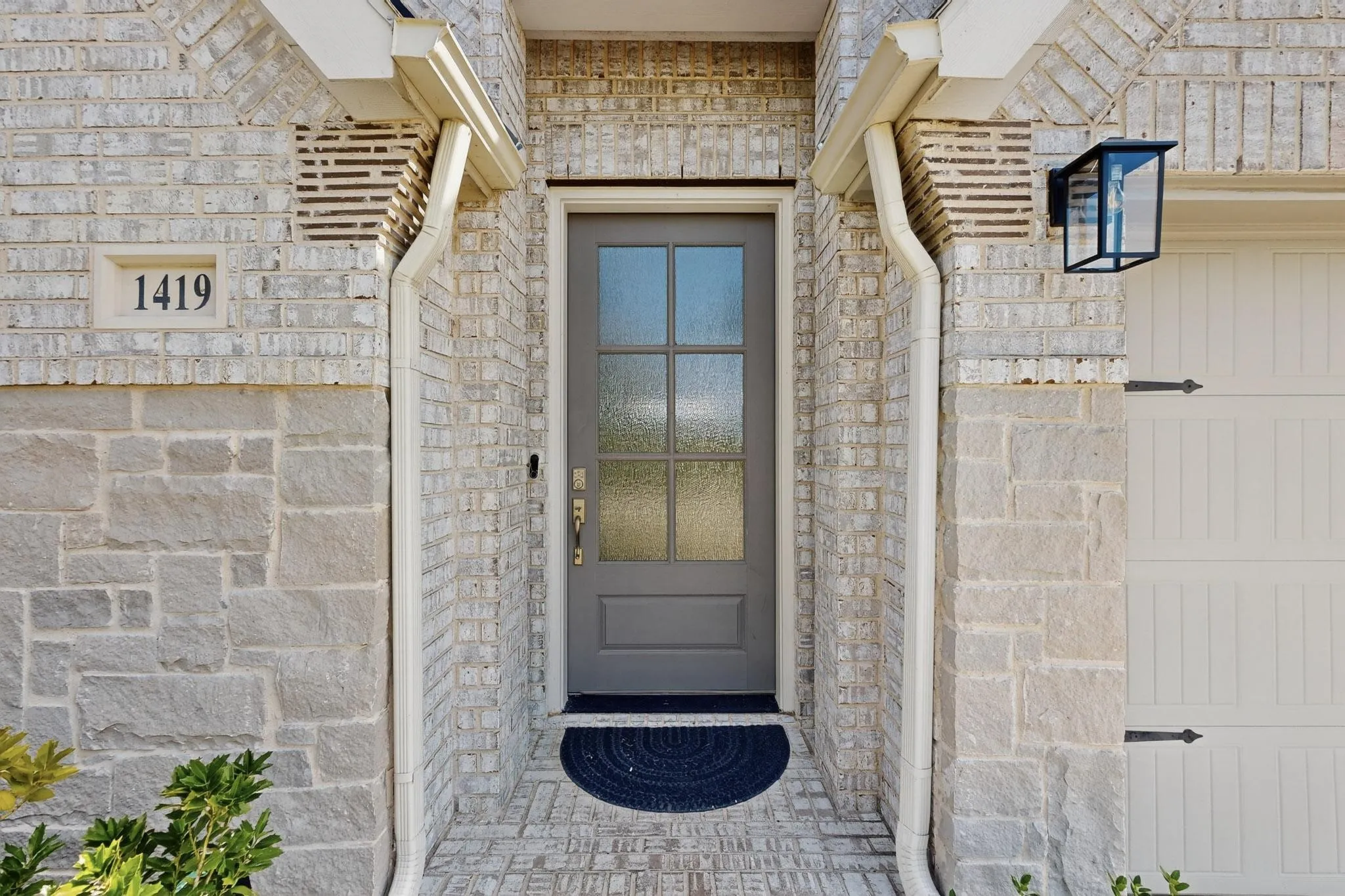 View of exterior entry with brick siding and stone siding