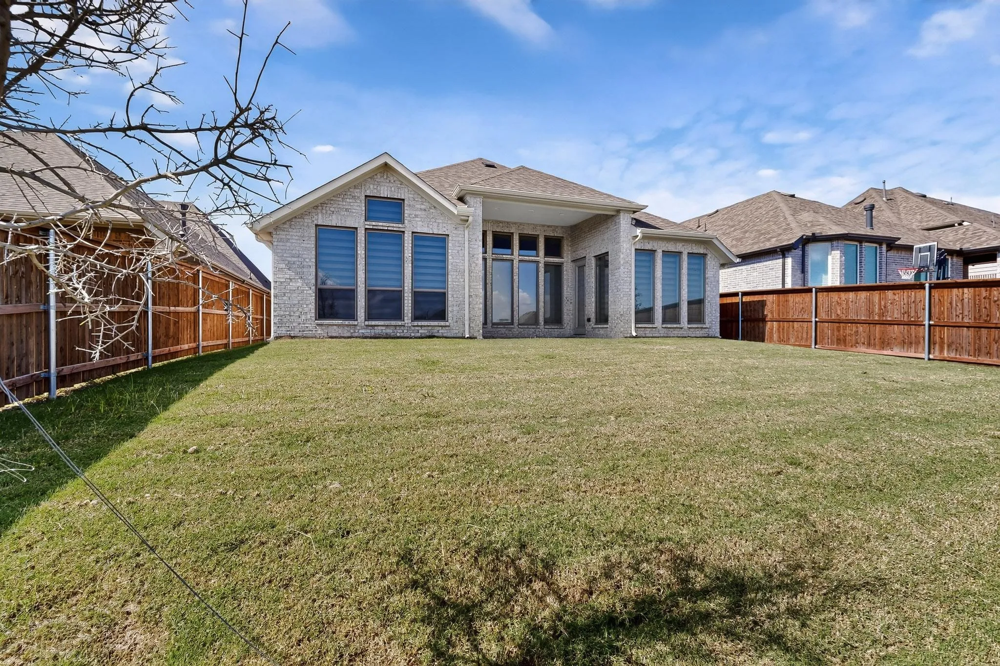 Rear view of house with a fenced backyard, a patio area, and brick siding