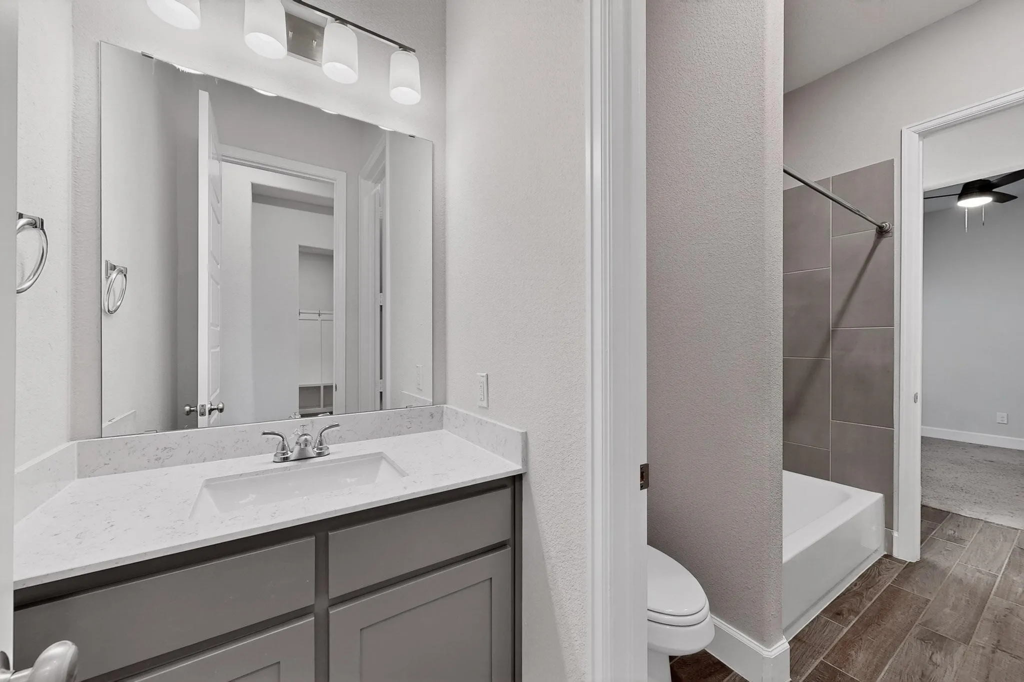 Full bath featuring vanity, wood tiled floors, and washtub / shower combination