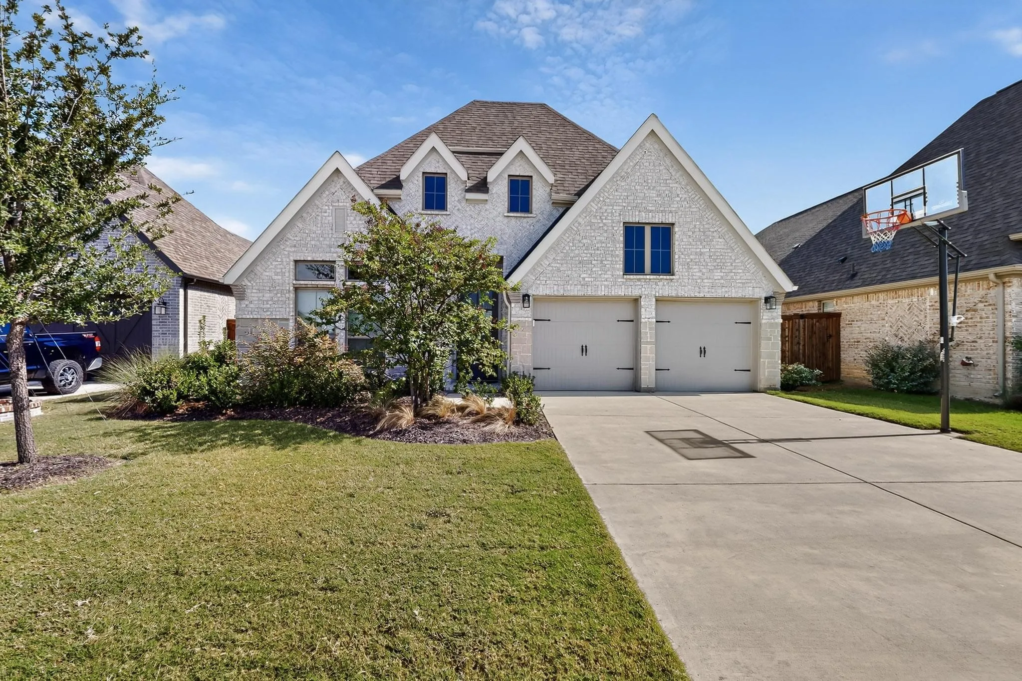 View of front of house featuring brick siding, a garage, concrete driveway, and roof with shingles