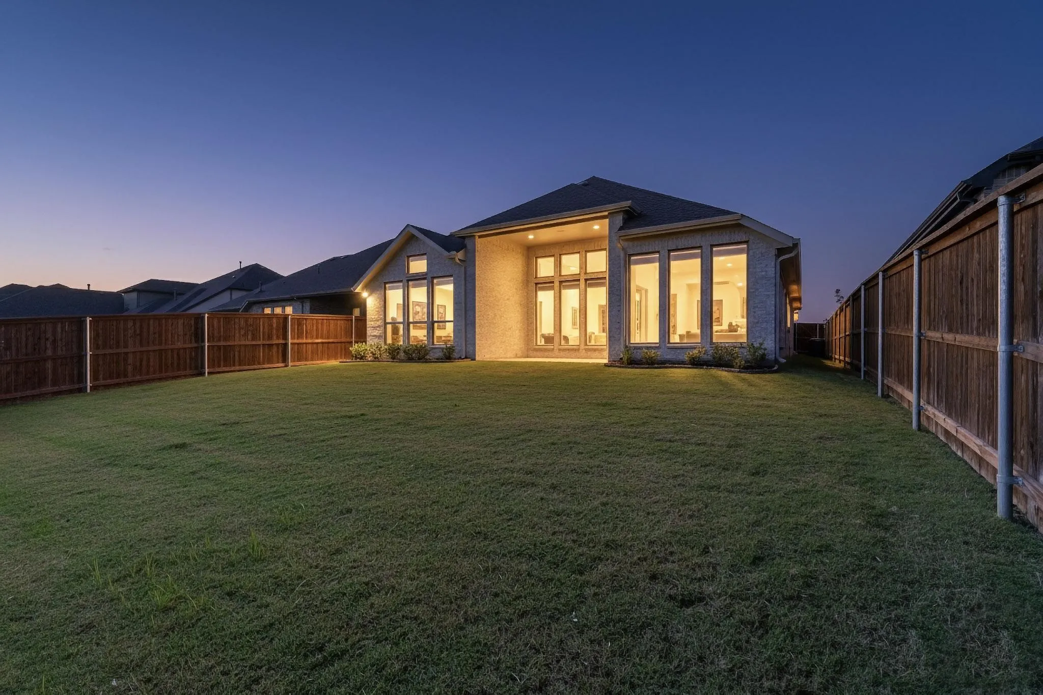 Rear view of house with a fenced backyard and a patio area
