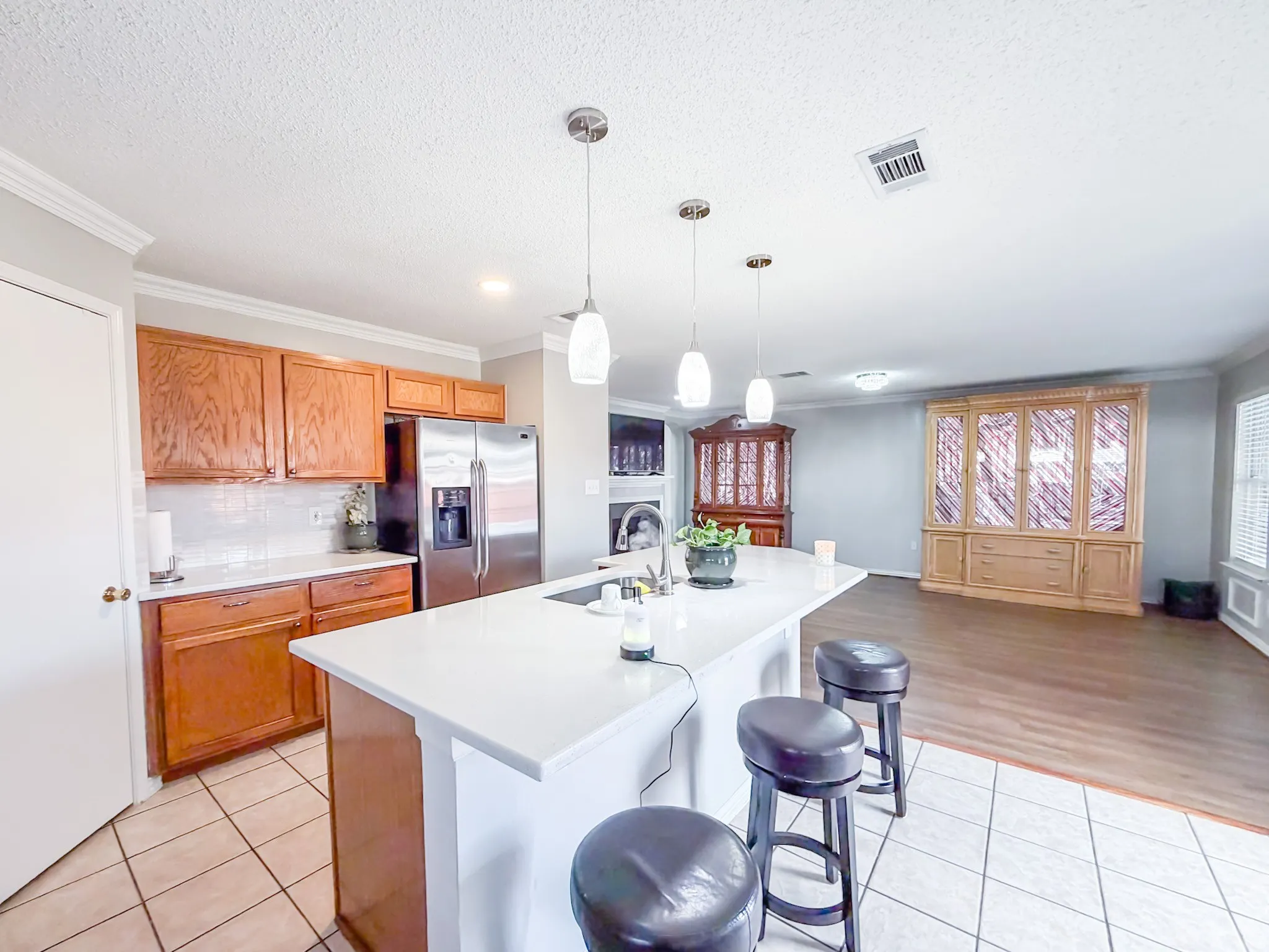 Kitchen featuring a peninsula island with pendant lighting, white countertops, and integrated sink