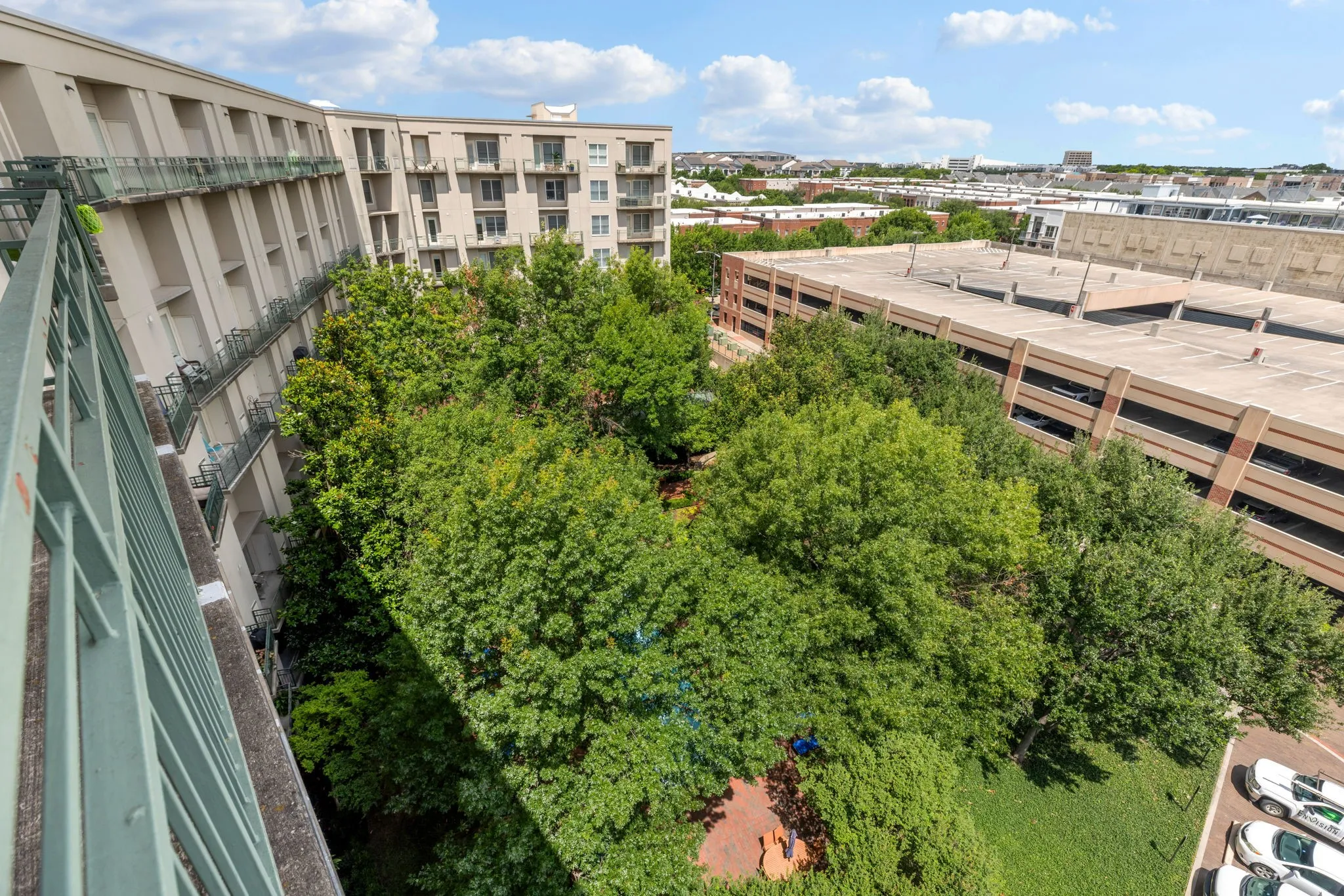 View from the rear balcony down to the resident's courtyard. Beneath this canopy of trees you'll find a pool, firepit, seating areas and a grilling station.