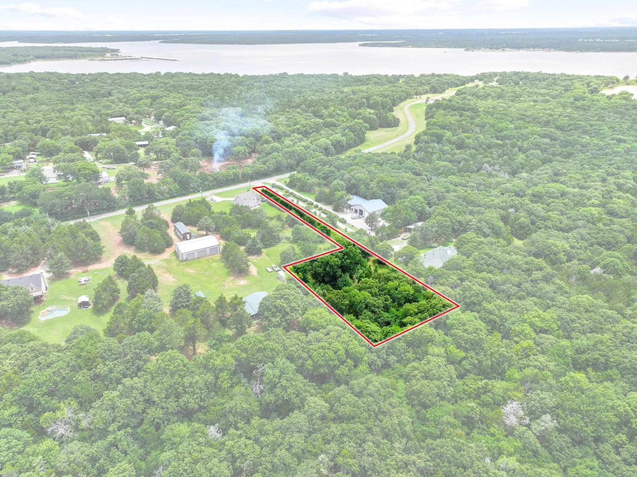 Expansive wooded parcel featuring mature trees and clear boundaries, situated near a substantial body of water