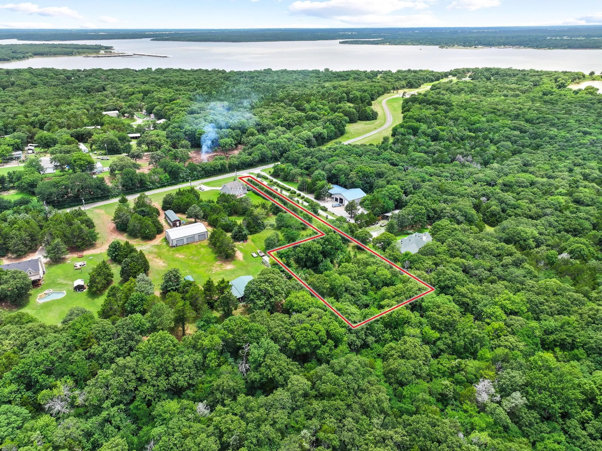 Expansive treed parcel outlined in red, featuring a partial clearing and surrounding dense foliage