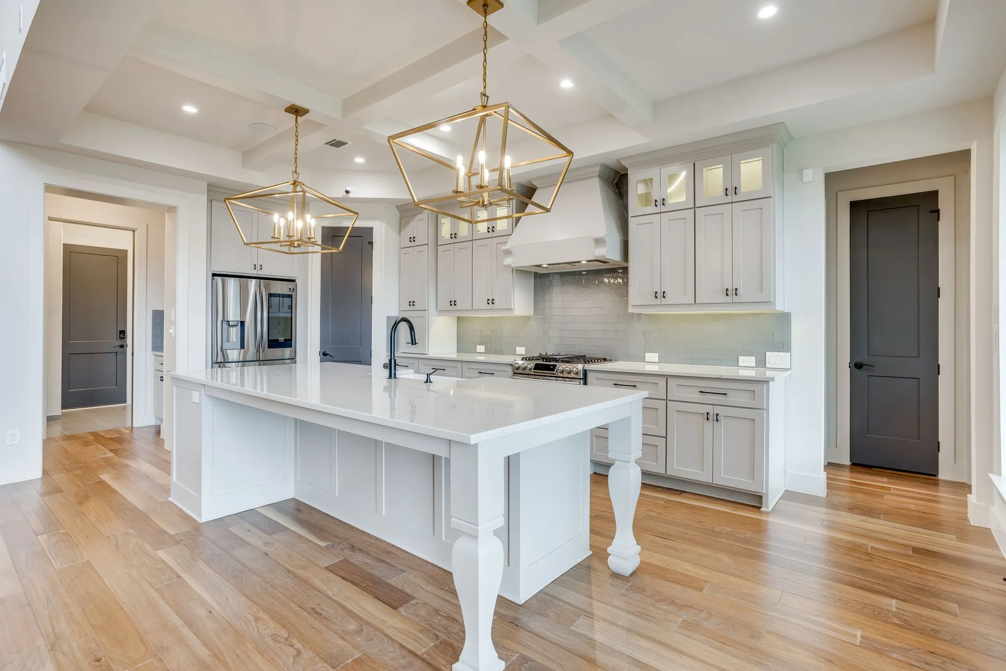 Gourmet kitchen featuring a substantial island with seating, a professional-grade range, stainless steel appliances, and ceiling-height cabinetry