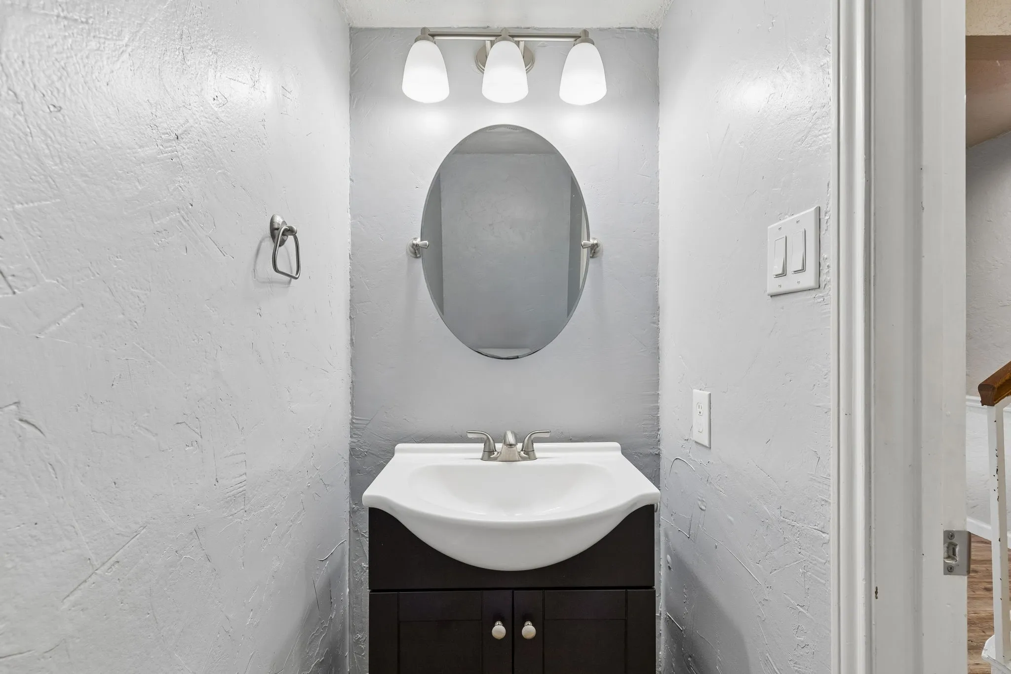 Bathroom with vanity and a textured wall