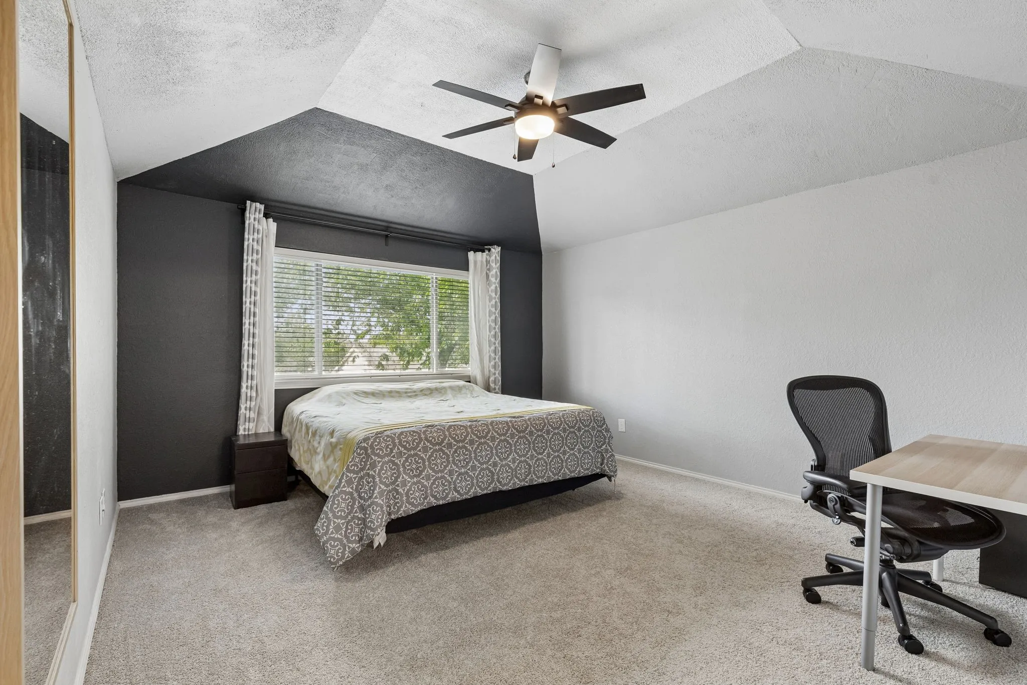 Bedroom with light carpet, a desk, and ceiling fan