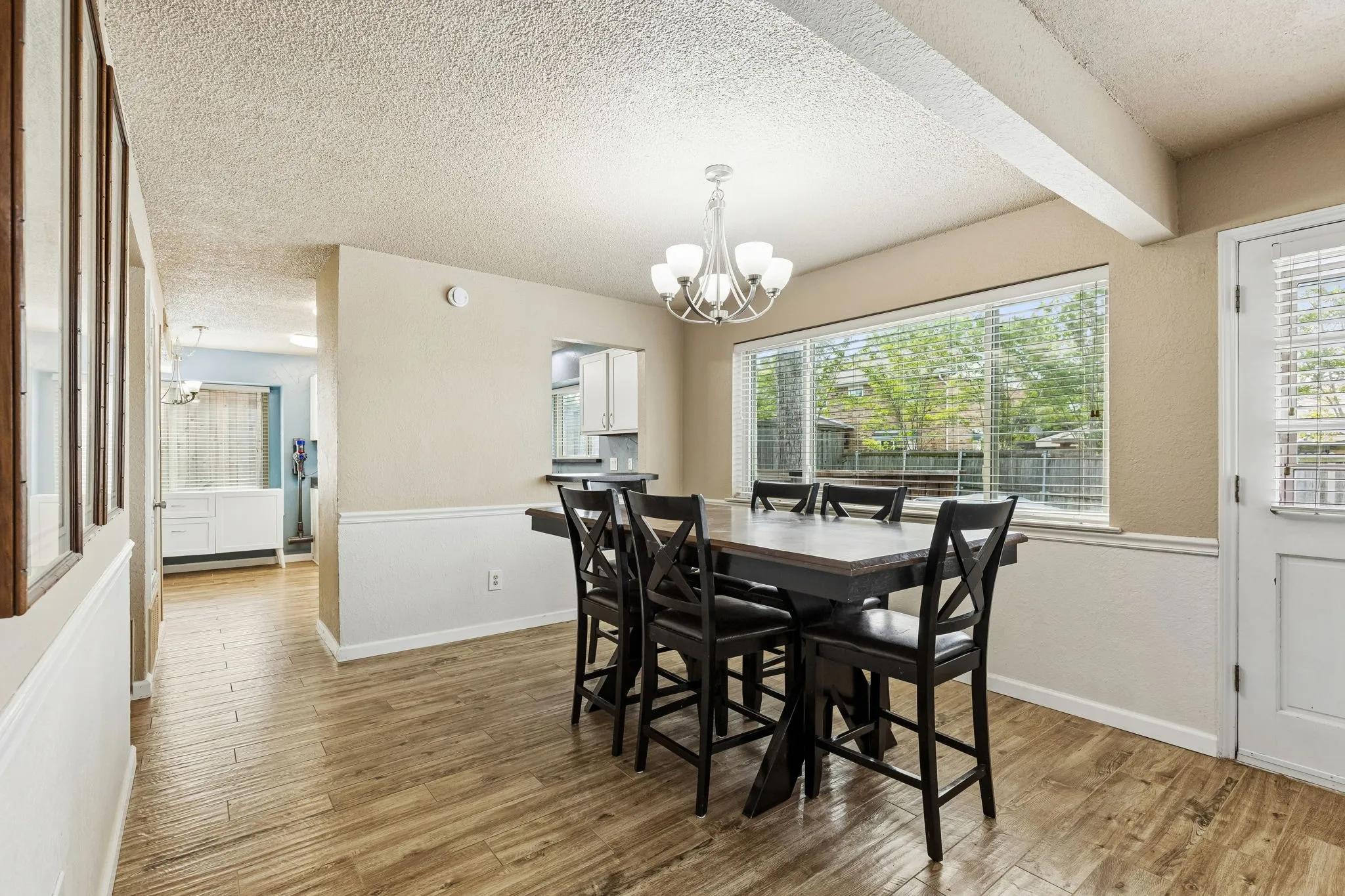 Dining room featuring a chandelier, light wood-type flooring, and a textured ceiling