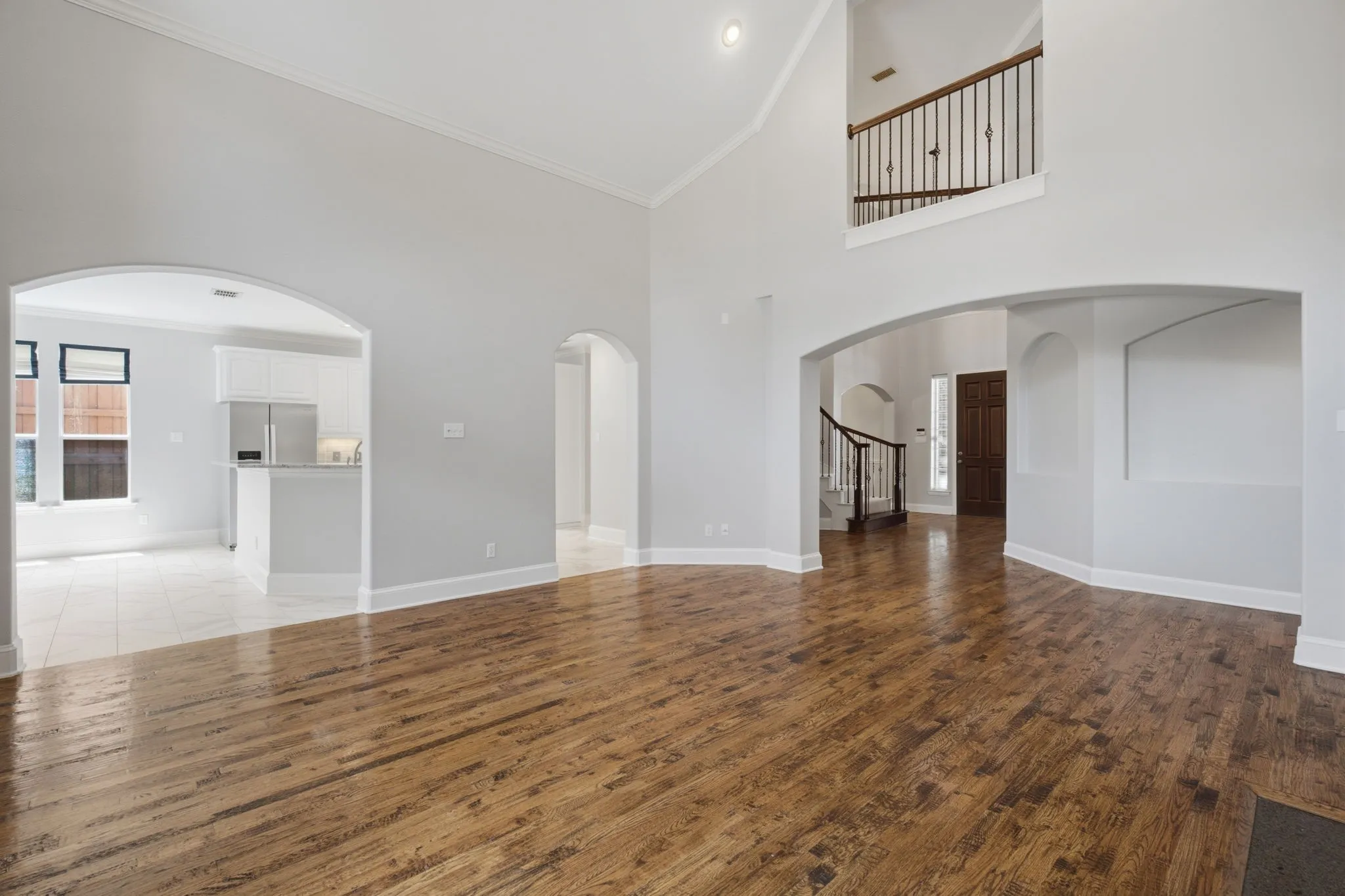 The spacious and inviting family room features an open-concept layout with a seamless transition into the breakfast nook and gourmet kitchen, highlighted by a convenient breakfast bar that perfects the flow for casual dining and daily living.