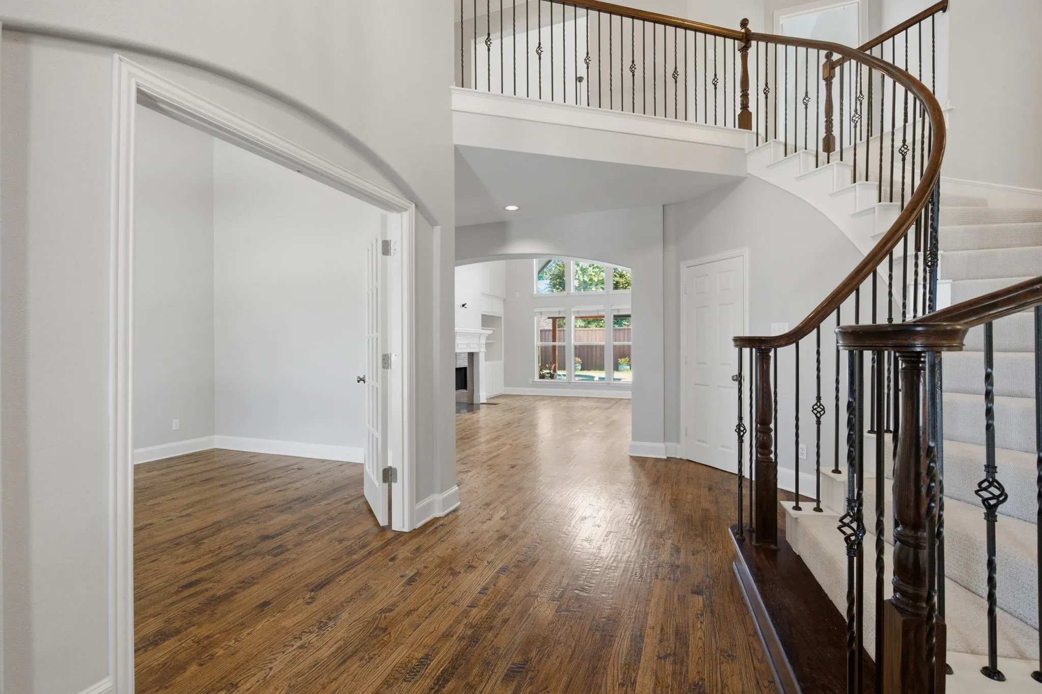 This stunning, bright entryway features soaring vaulted ceilings and elegant double glass doors that seamlessly lead into the private, professional home office space, perfect for remote work or study.