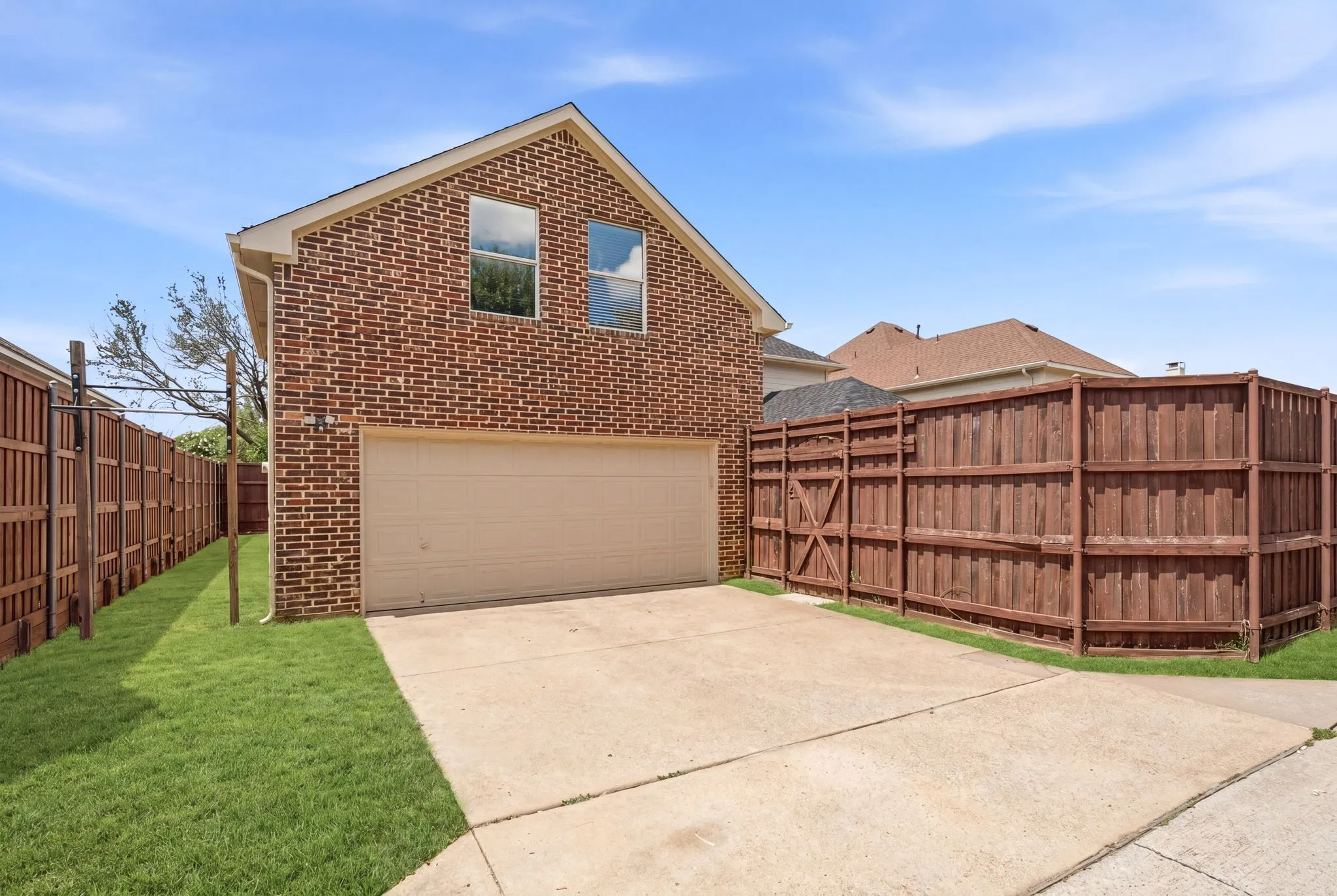 Rear driveway with gated backyard access and a tall privacy fence. Exterior freshly painted.