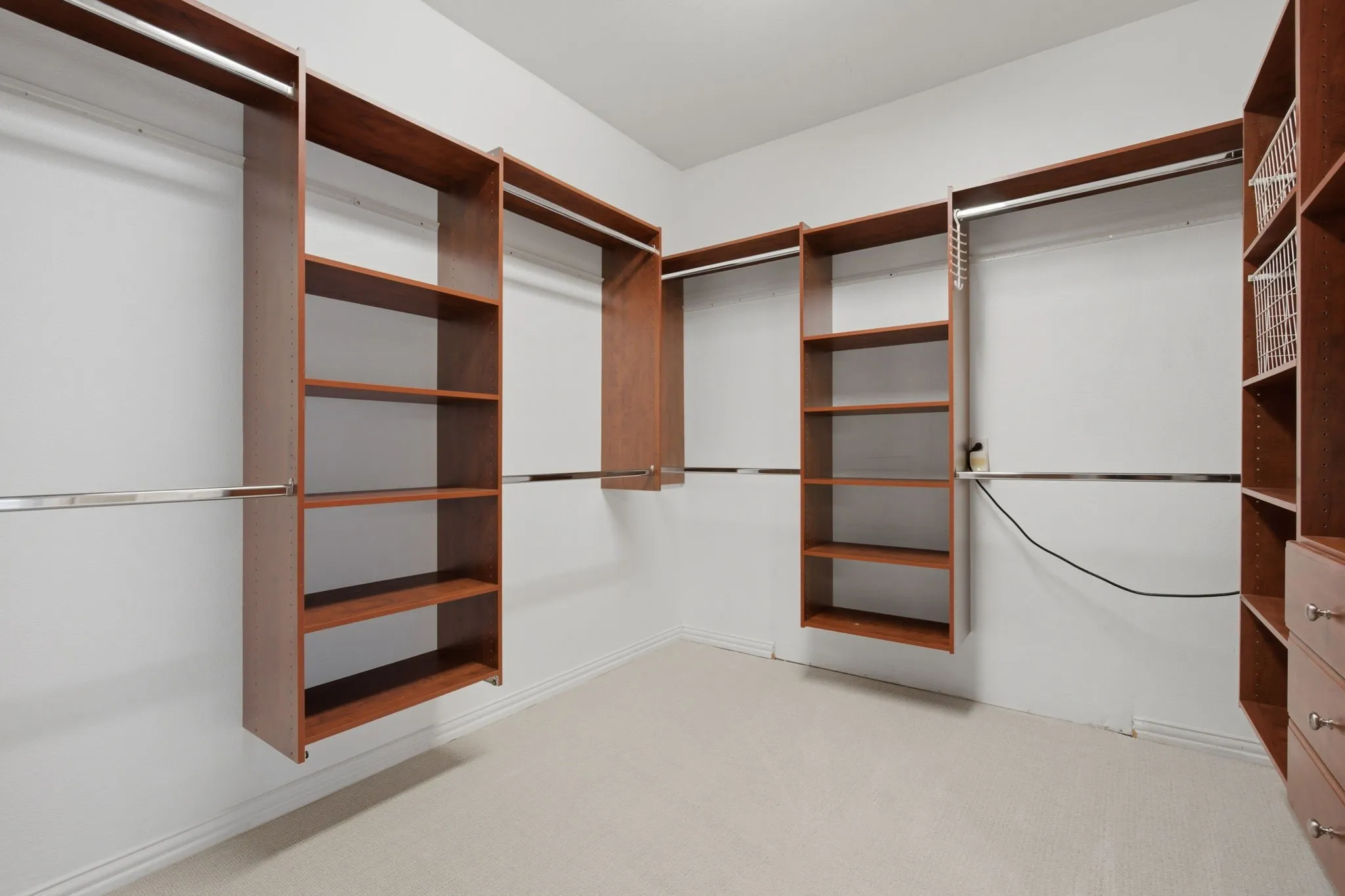 This property features expansive and beautifully organized walk-in closets that provide ample storage space, custom shelving, and a sophisticated design that enhances the overall appeal and functionality of the primary bedroom suite.