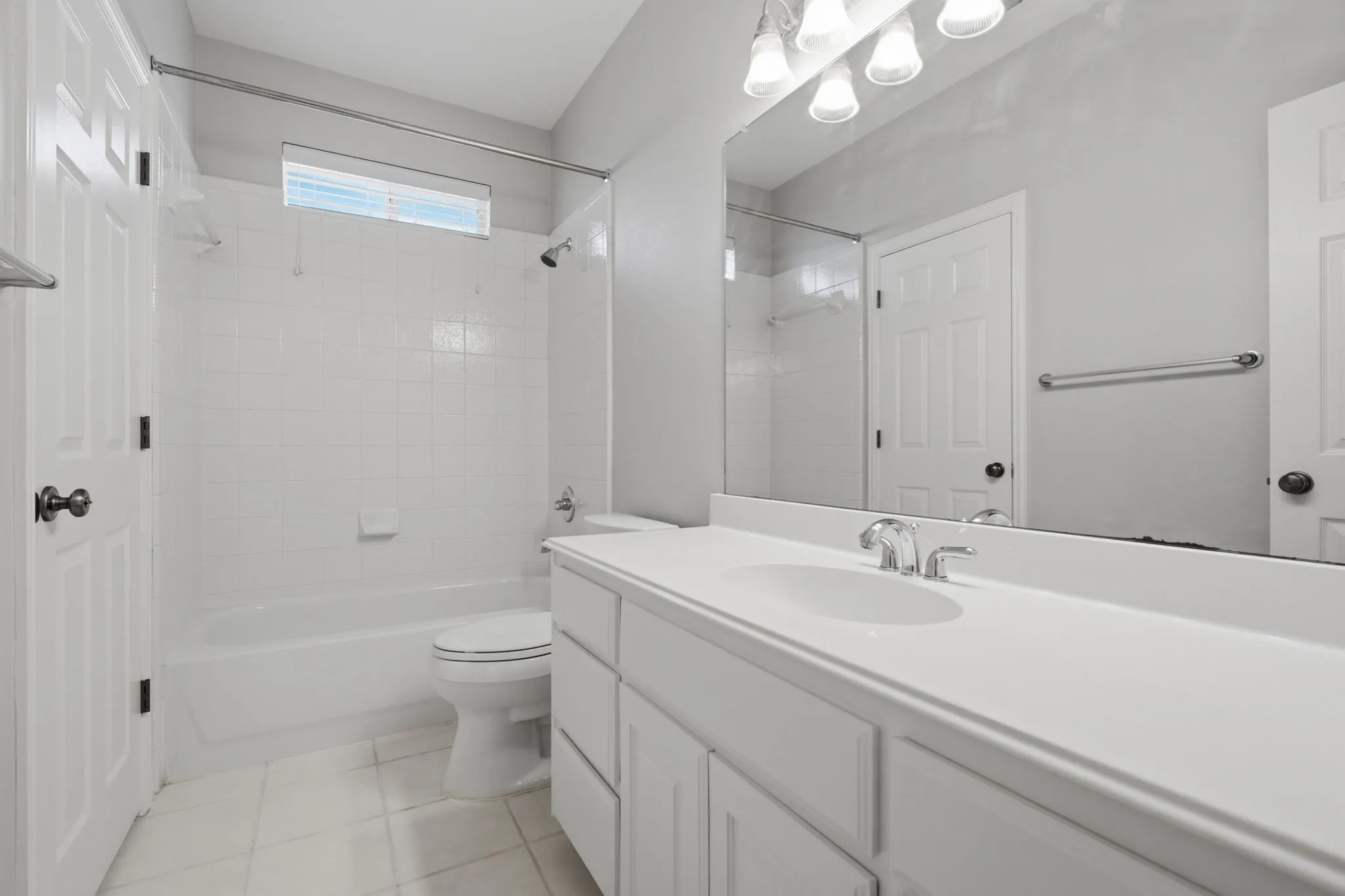 This spacious and fully renovated downstairs bathroom features convenient dual-entry access, allowing for private use from the secondary bedroom as well as easy entry from the main hallway for guests.