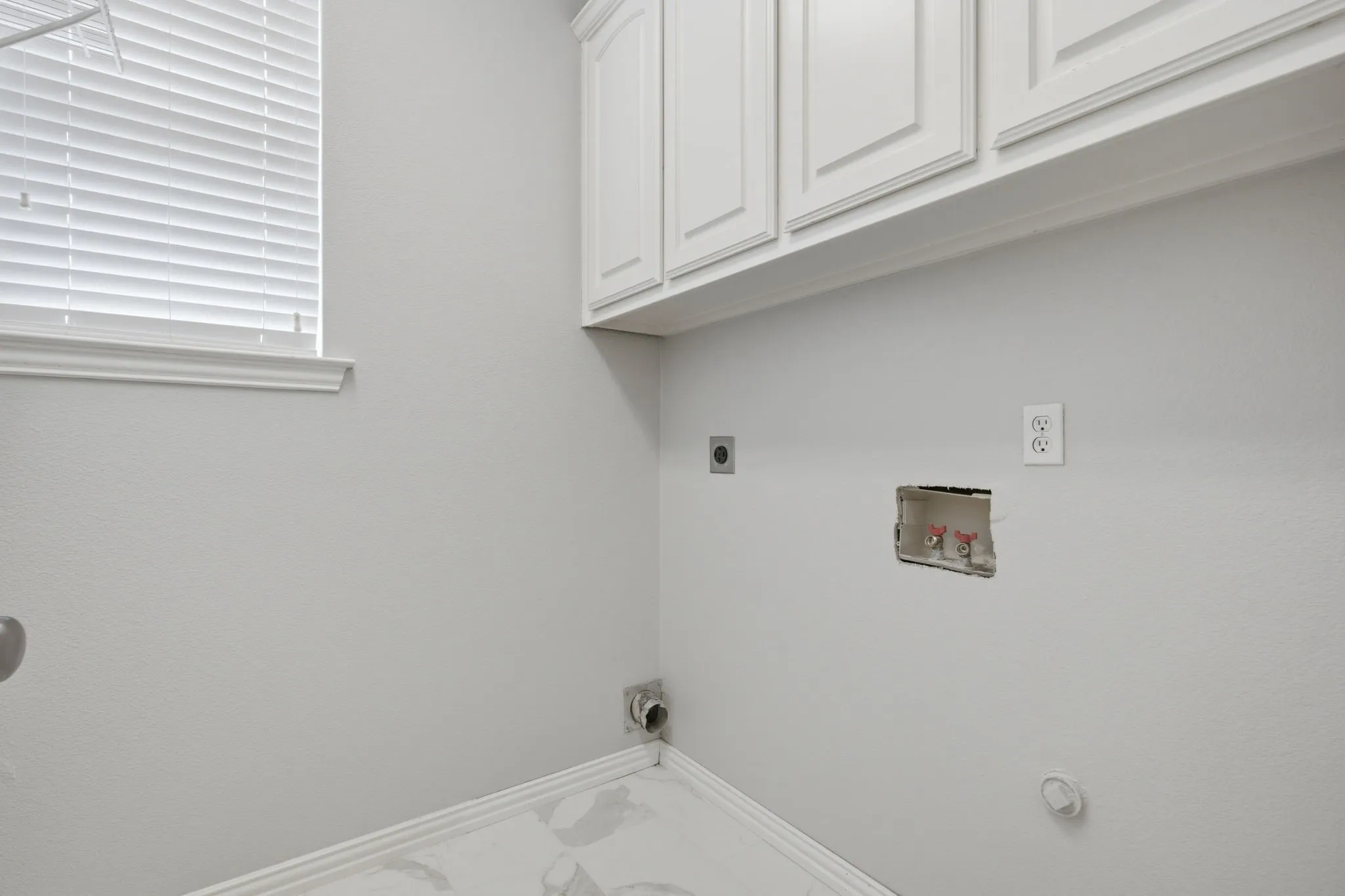Laundry room with cabinets & window