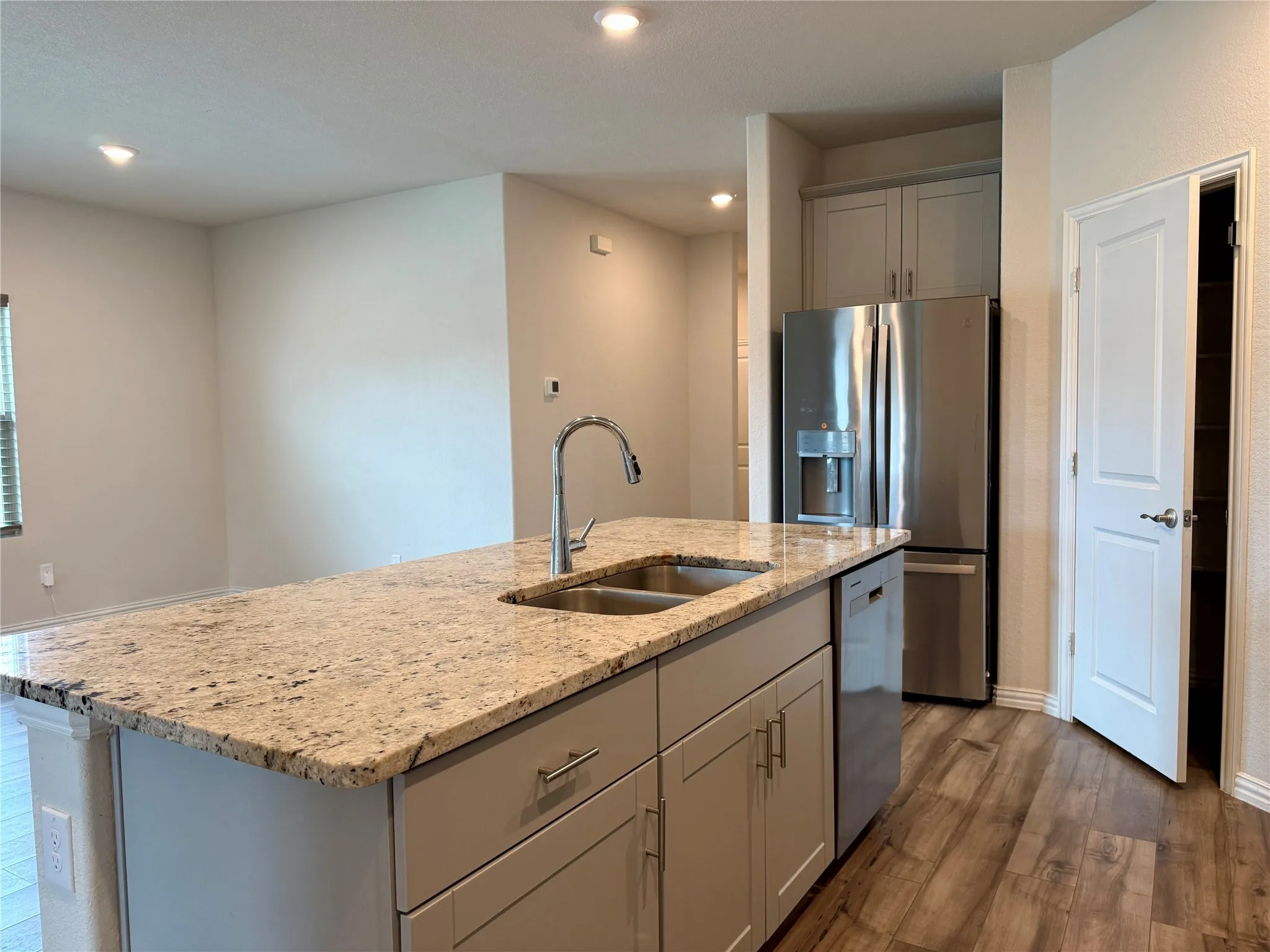 Kitchen island featuring a double-basin sink and a gooseneck faucet