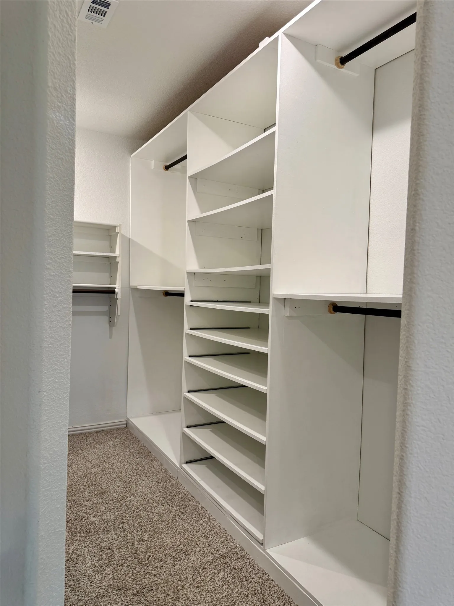 Custom closet system featuring multiple shelves and hanging rods