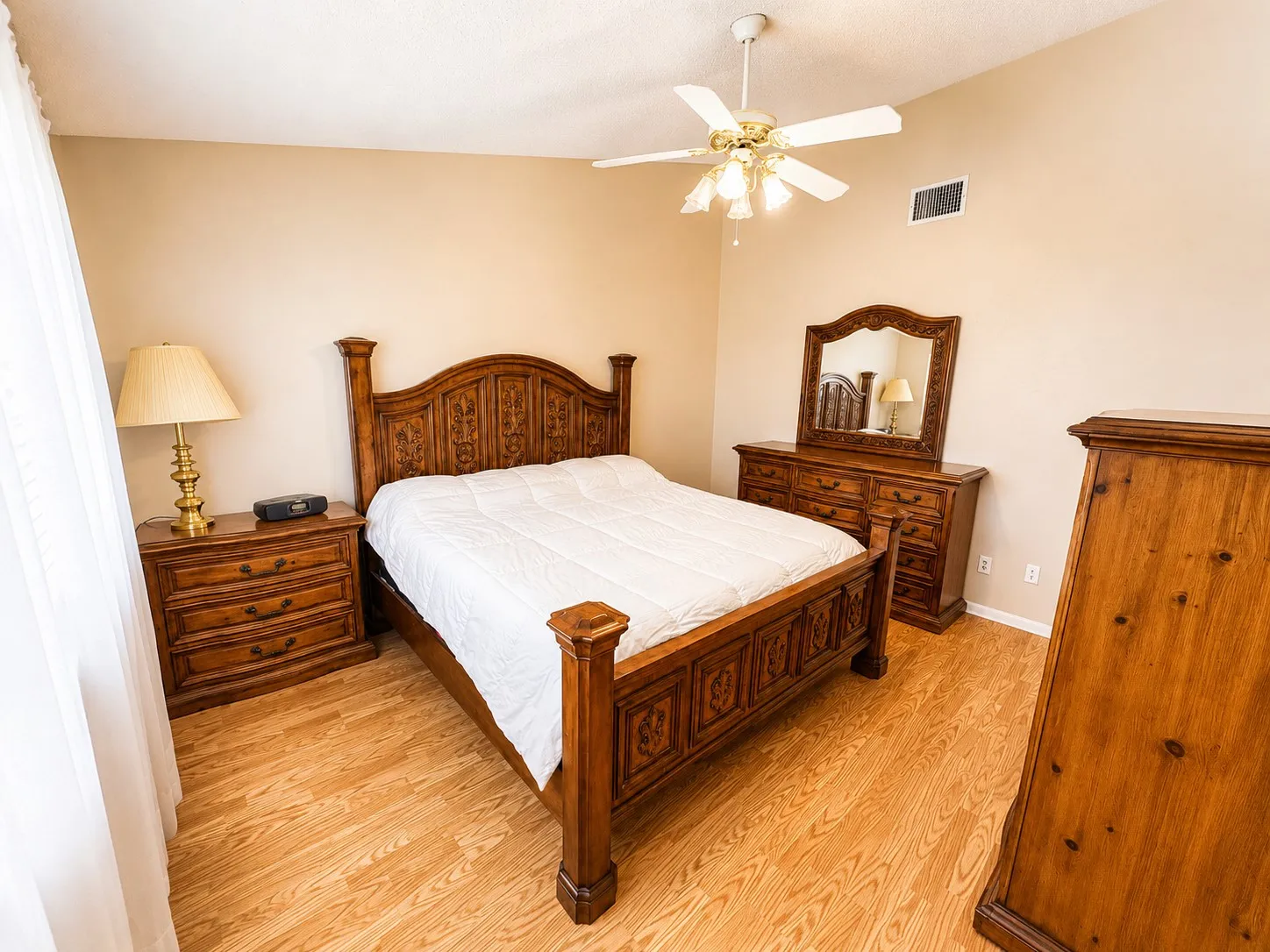 Bedroom featuring wood-finish flooring, a ceiling fan with integrated lighting, and neutral wall tones
