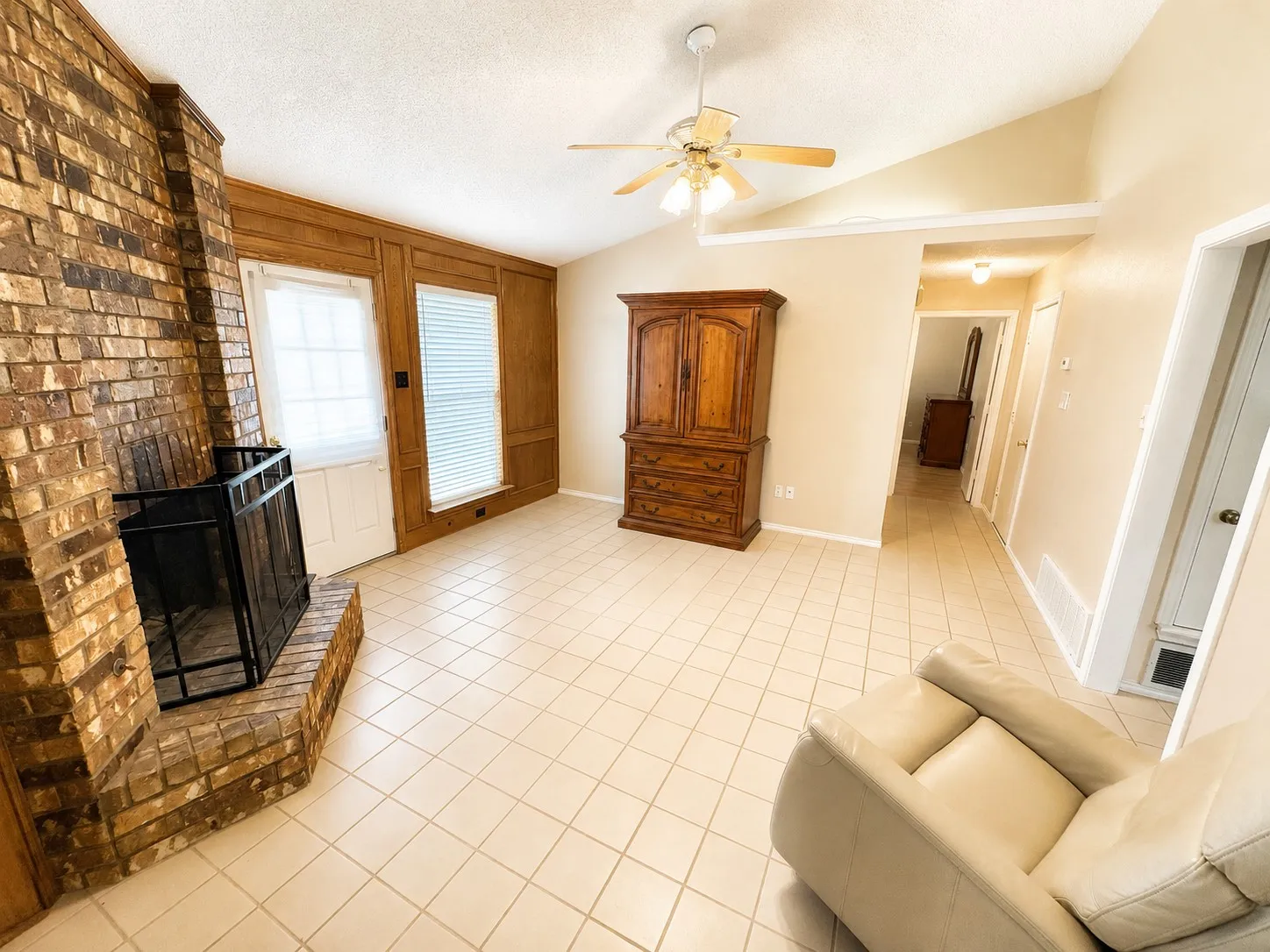 Living room featuring a brick fireplace with gas starter