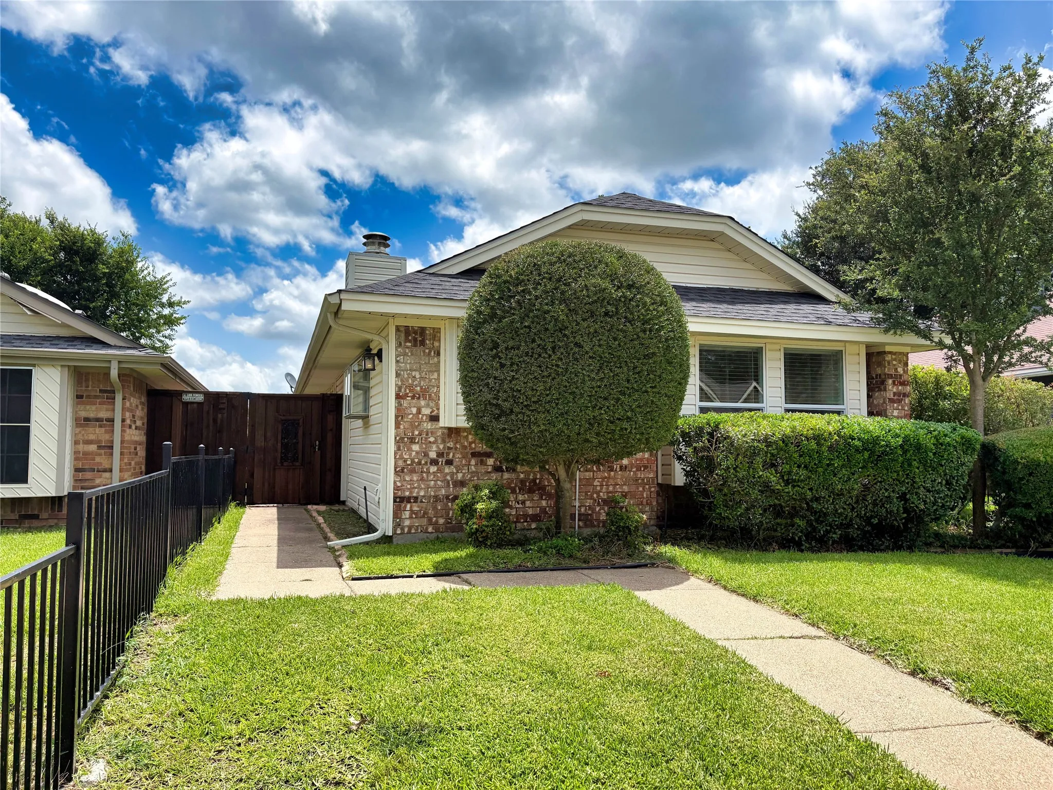 Brick and siding exterior featuring a dark asphalt shingle roof