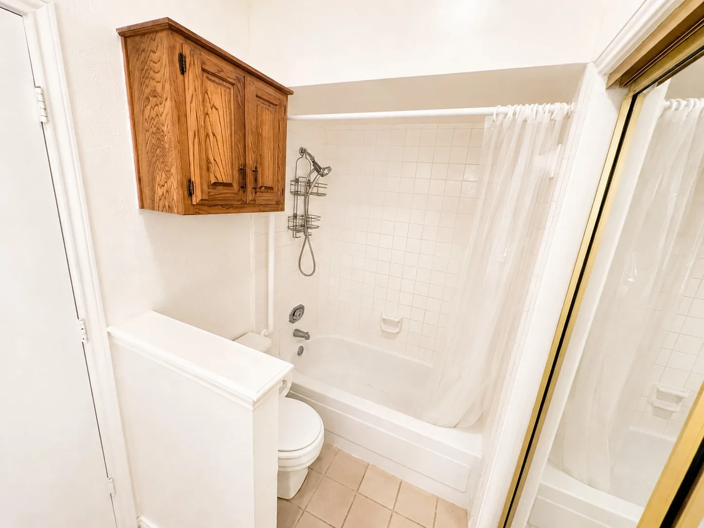 Bathroom featuring a white bathtub, ceramic tile flooring, and a white toilet