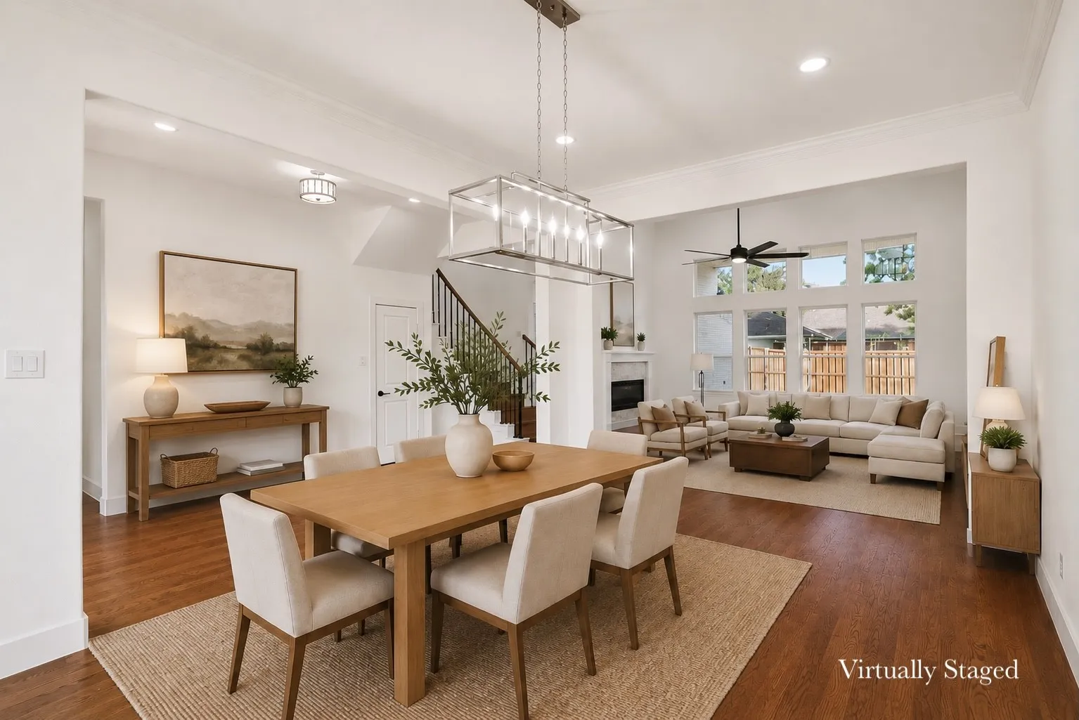 Open-concept living space featuring wood-finish flooring, a contemporary linear chandelier, recessed lighting, and crown molding