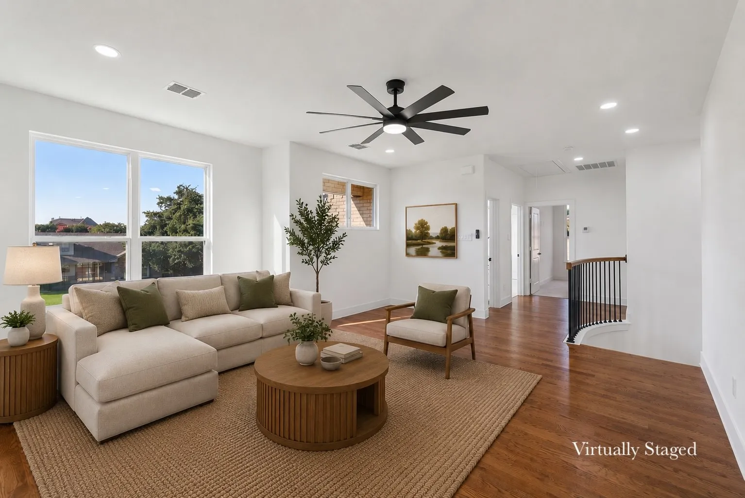 Open-concept living area with wood-finish flooring and recessed lighting
