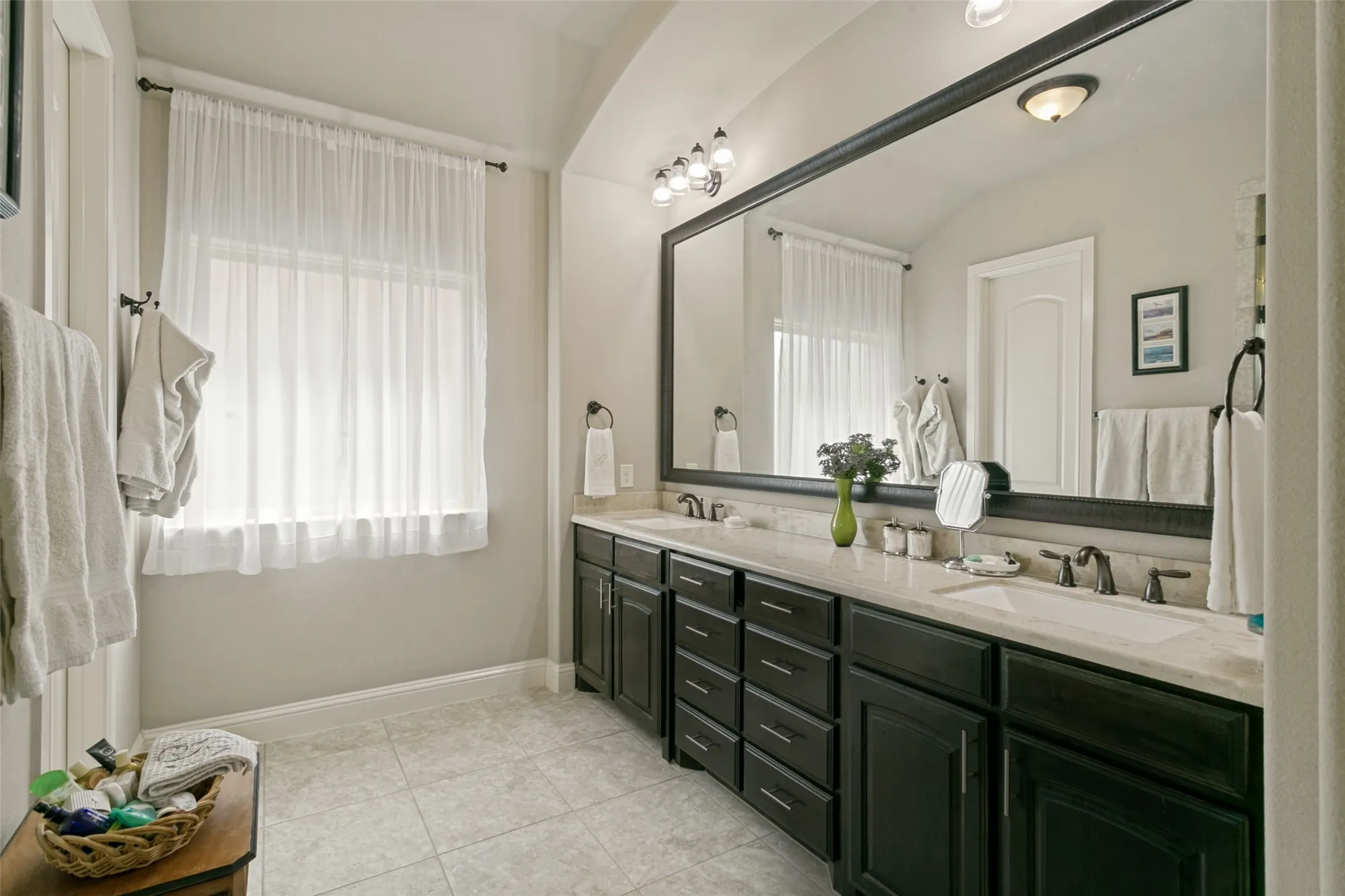 Dual vanity featuring dark wood cabinetry and integrated sinks with bronze-finish fixtures