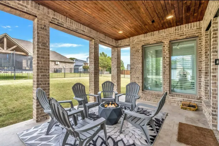 Covered patio featuring a wood-finish ceiling with recessed lighting, brick columns and exterior wall, and a concrete floor