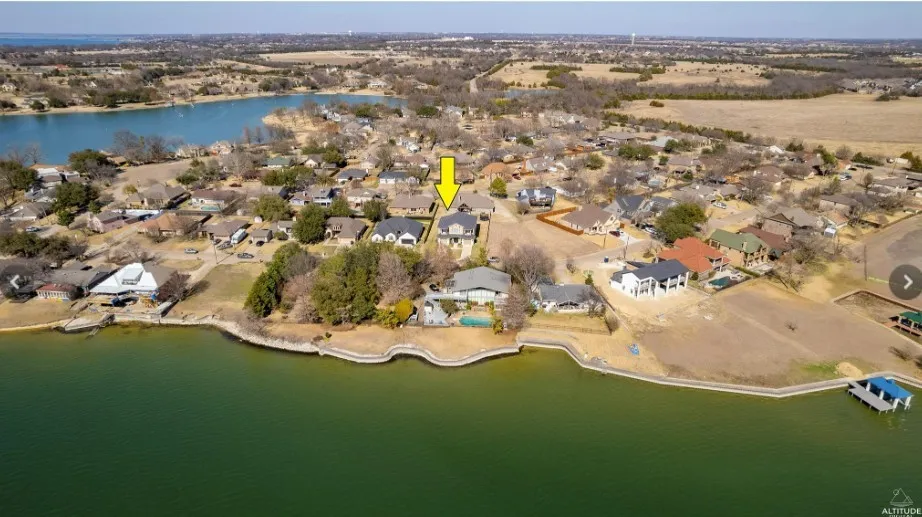 Waterfront property featuring a lake, residential neighborhood, and mature trees