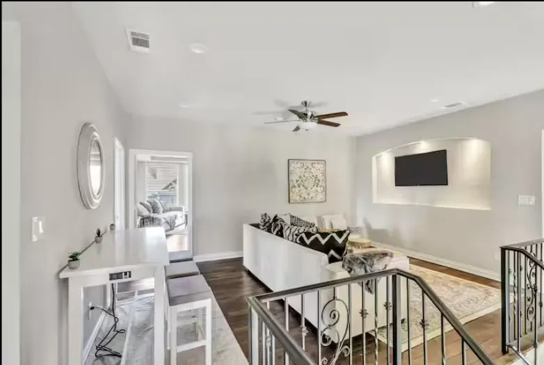 Open-concept living area featuring rich wood-finish flooring and a contemporary ceiling fan