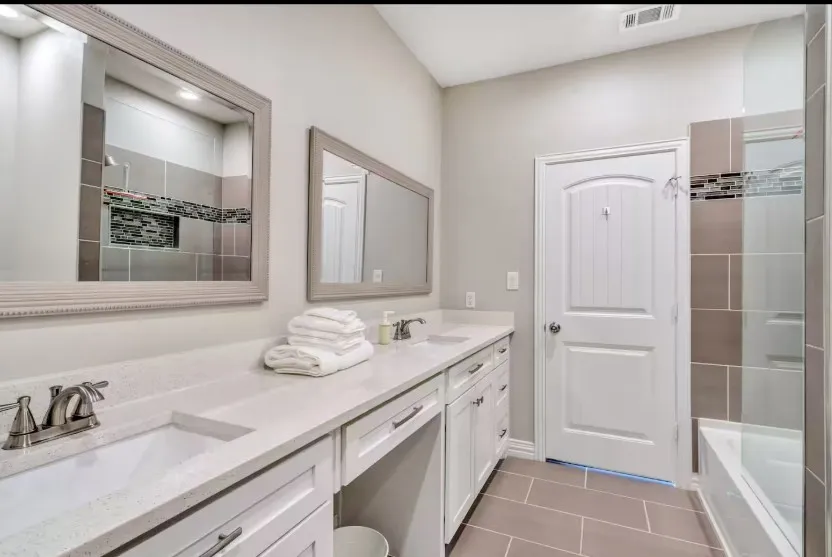 Bathroom featuring a dual vanity with undermount sinks and light-toned countertops