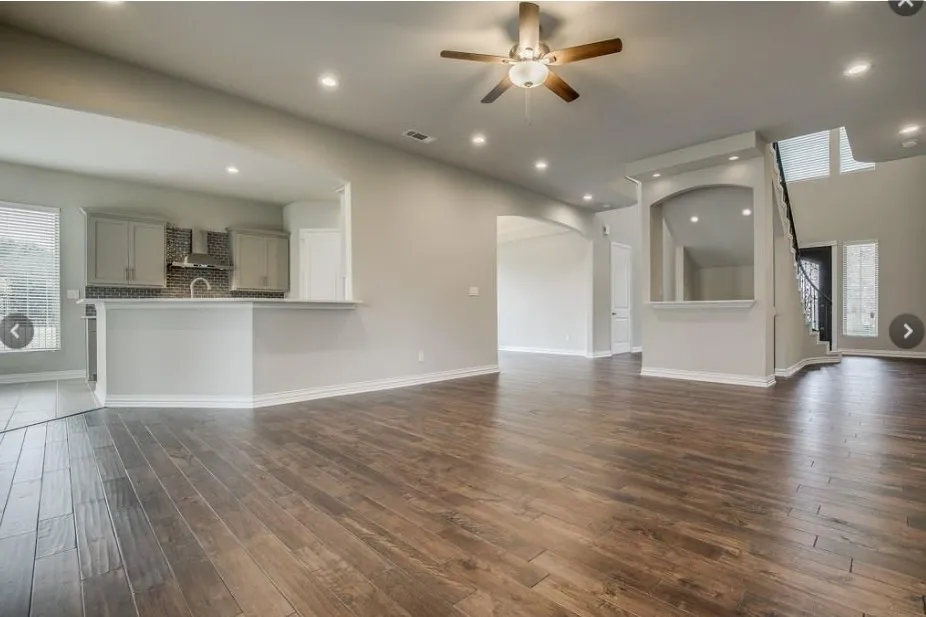 Spacious open-concept living area featuring wood-finish flooring, recessed lighting, and a ceiling fan