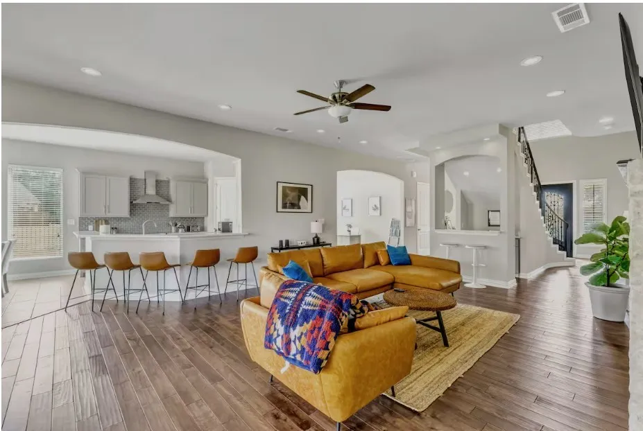 Spacious living area featuring rich wood-finish flooring and recessed lighting