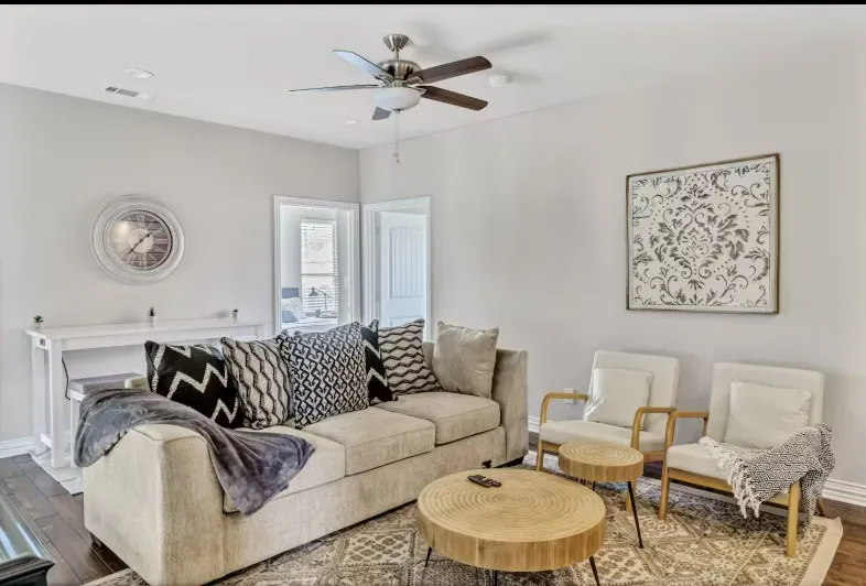 Well-lit living space featuring dark wood-finish flooring, recessed lighting, and a ceiling fan