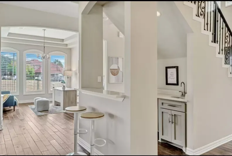 Wood-finish flooring throughout, with a built-in wet bar featuring a single basin sink and cabinet storage