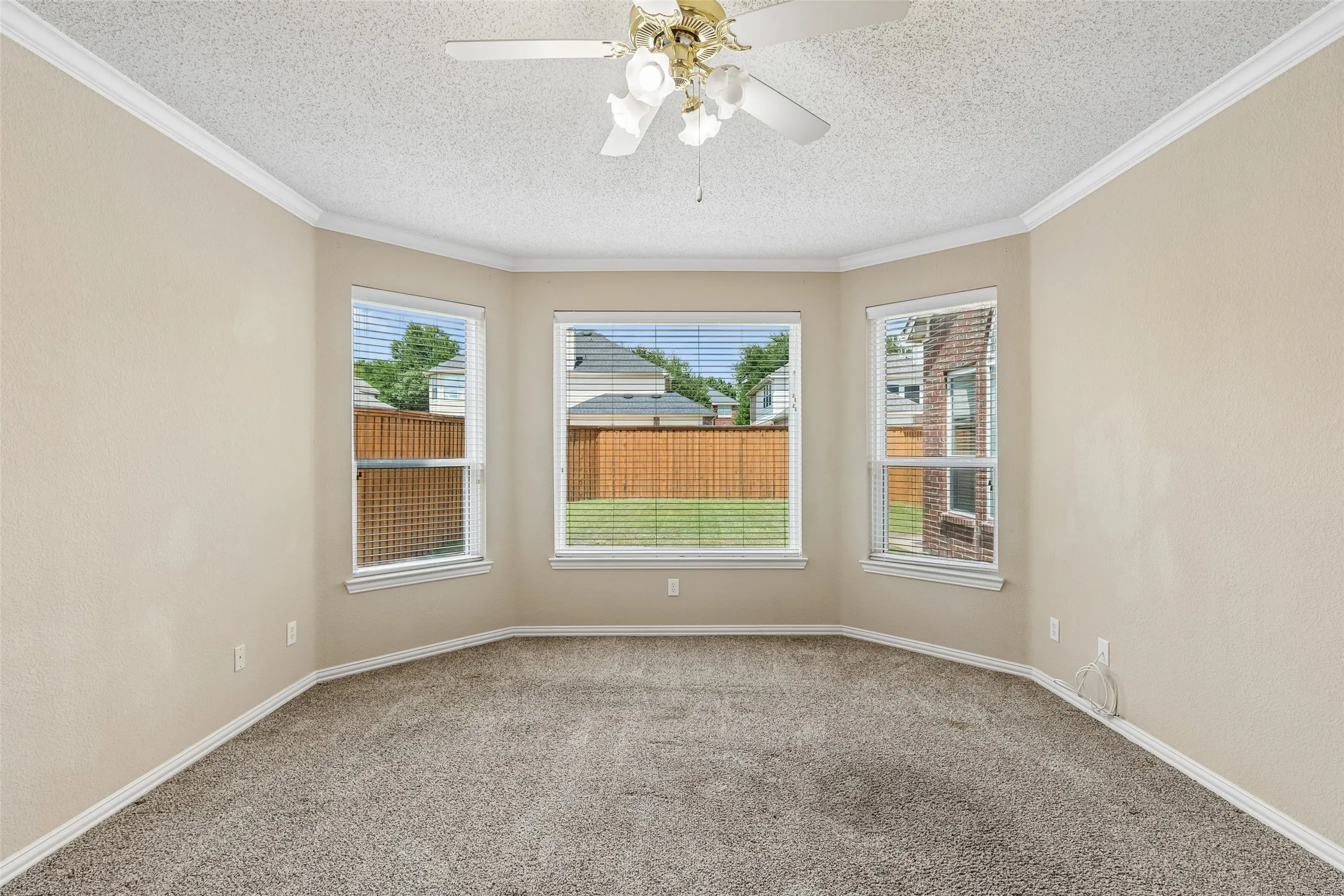 Spacious first floor primary bedroom with wall of windows looking outdoors.