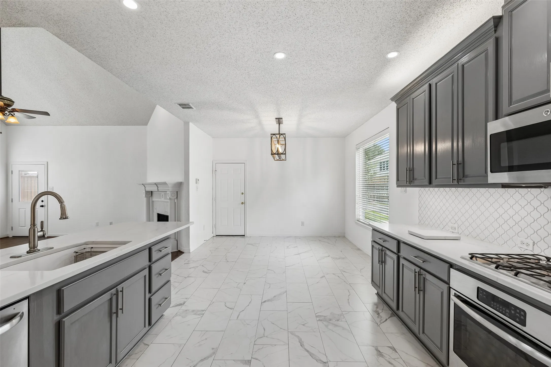 Cook's will enjoy this kitchen which has been remodeled with porcelain tile, updated cabinets, quartz counters and gas cooktop.