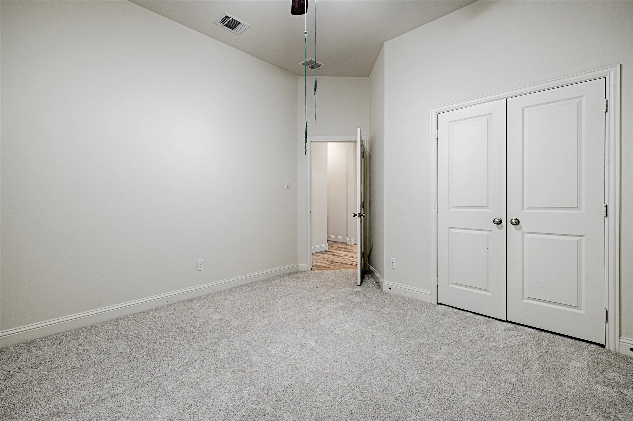 Room featuring light grey carpeting, white painted walls, and white trim