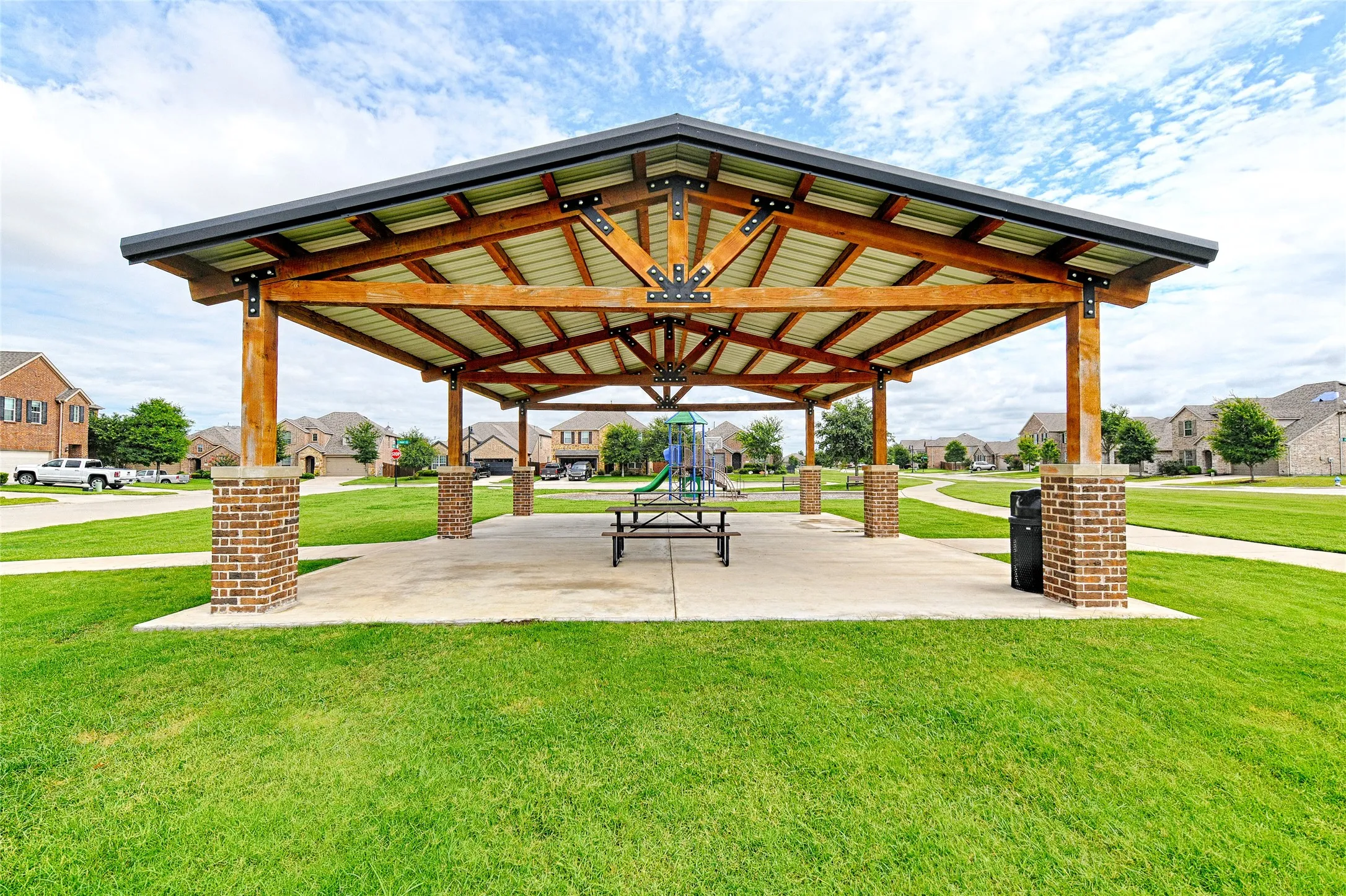 Community pavilion featuring a metal roof and exposed wood beam construction