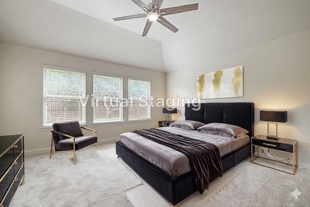 Vaulted ceiling bedroom featuring triple windows with blinds, carpeted flooring, and a ceiling fan with integrated lighting