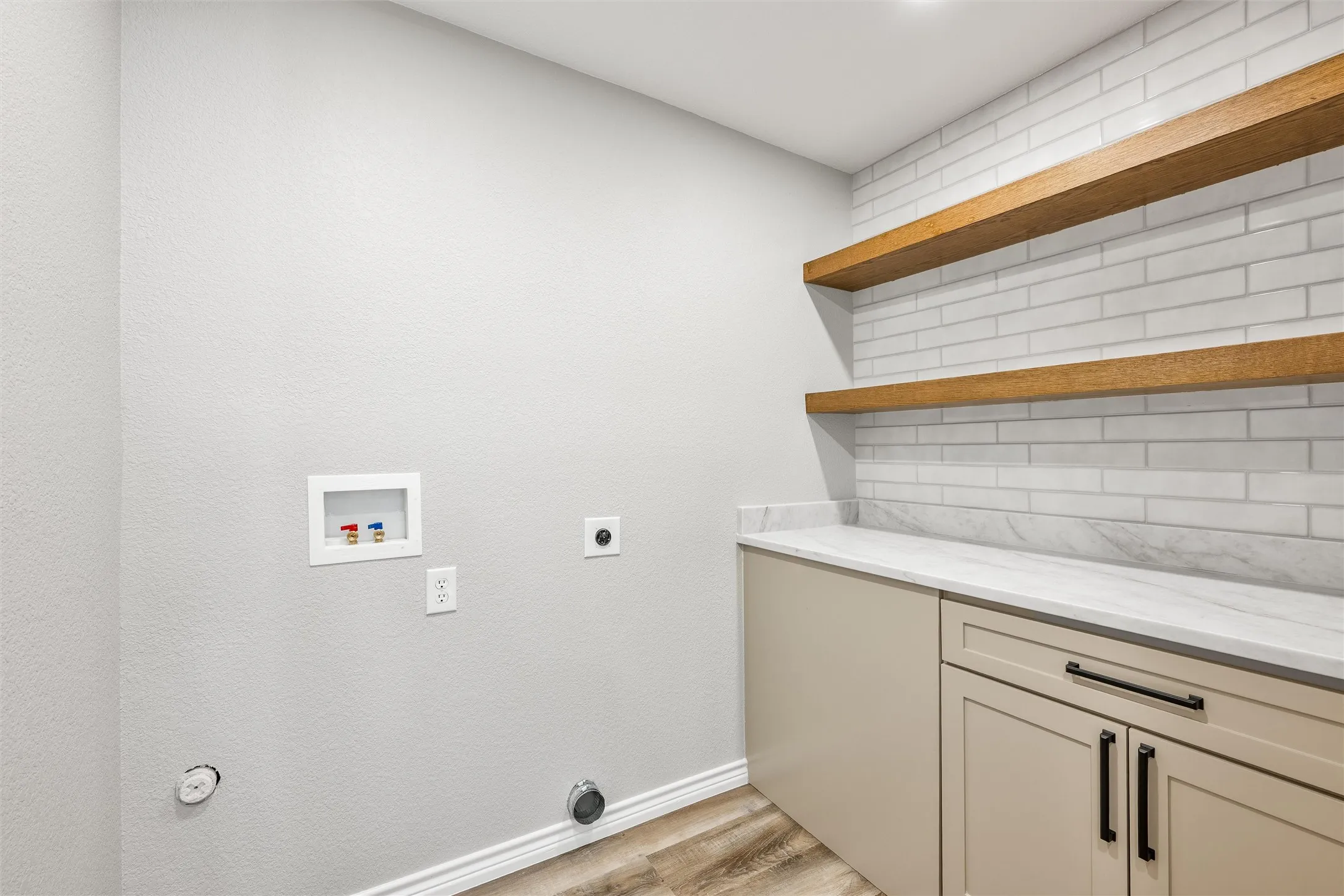 Custom laundry room with cabinets, quartz c-tops and shelves