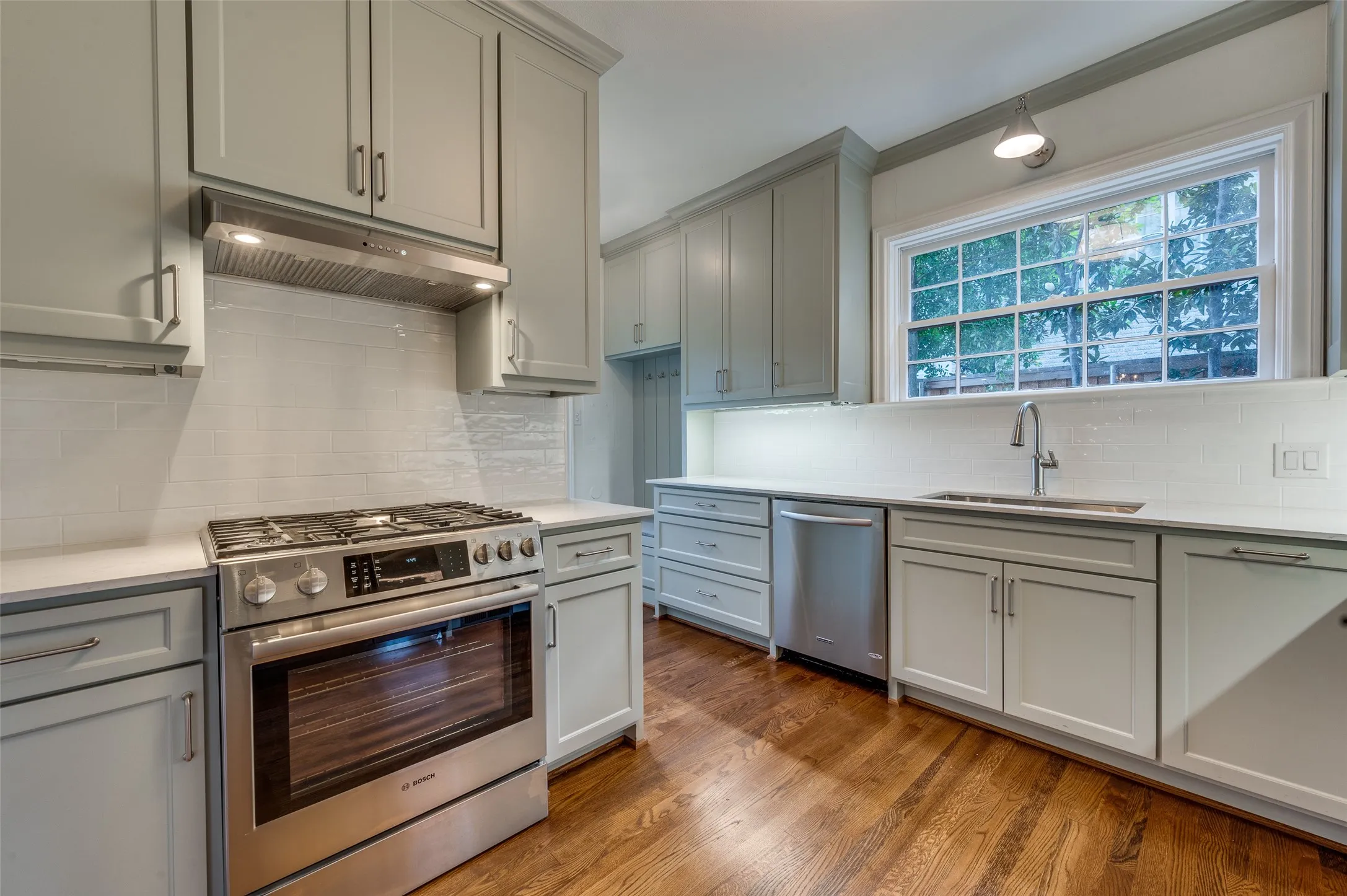 Just renovated kitchen with quartz countertops, stainless steel appliances and sage colored cabinetry.