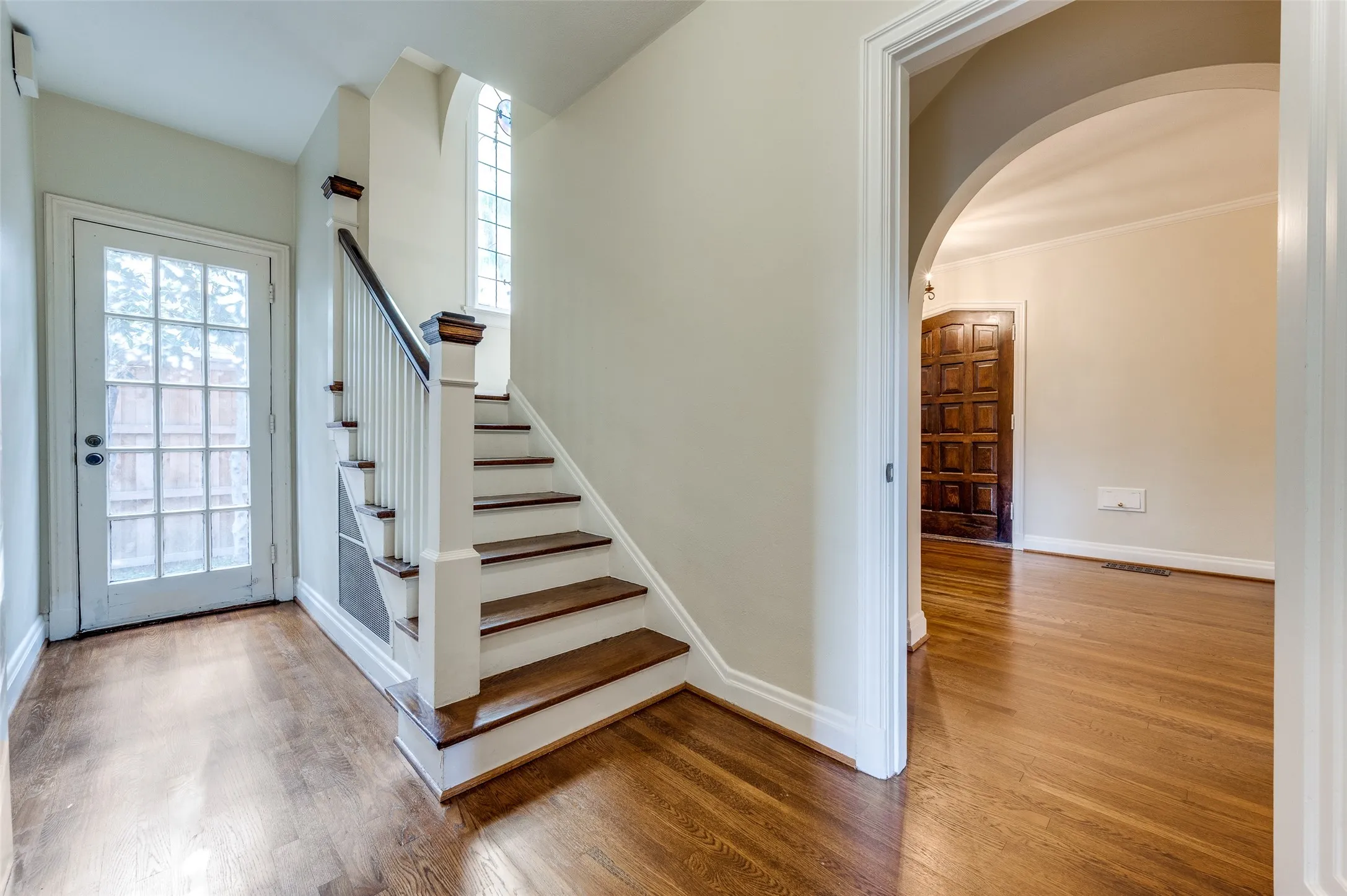 Elegant split staircase and classic archway.