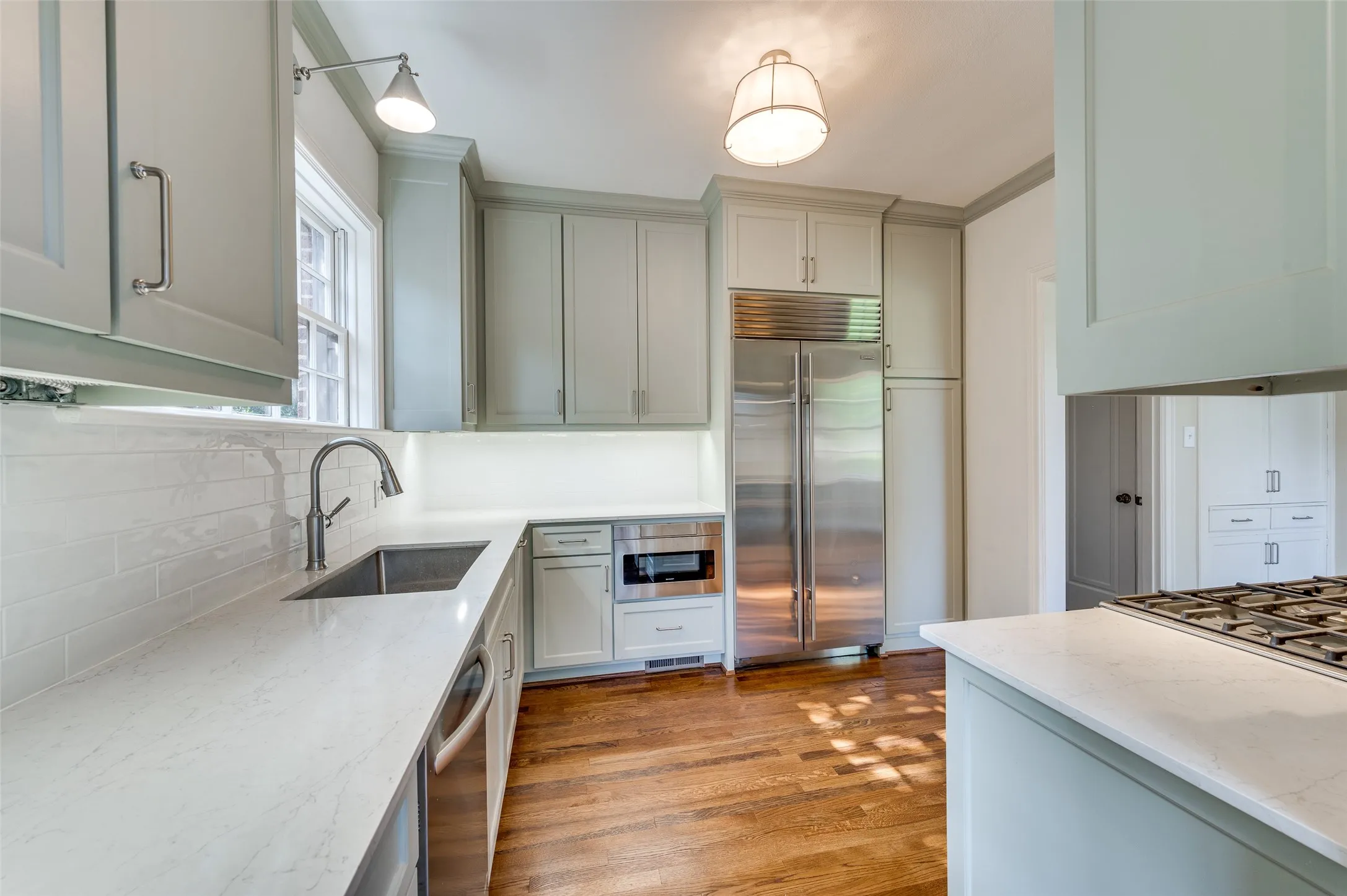 Just renovated kitchen with quartz countertops, stainless steel appliances and sage colored cabinetry.