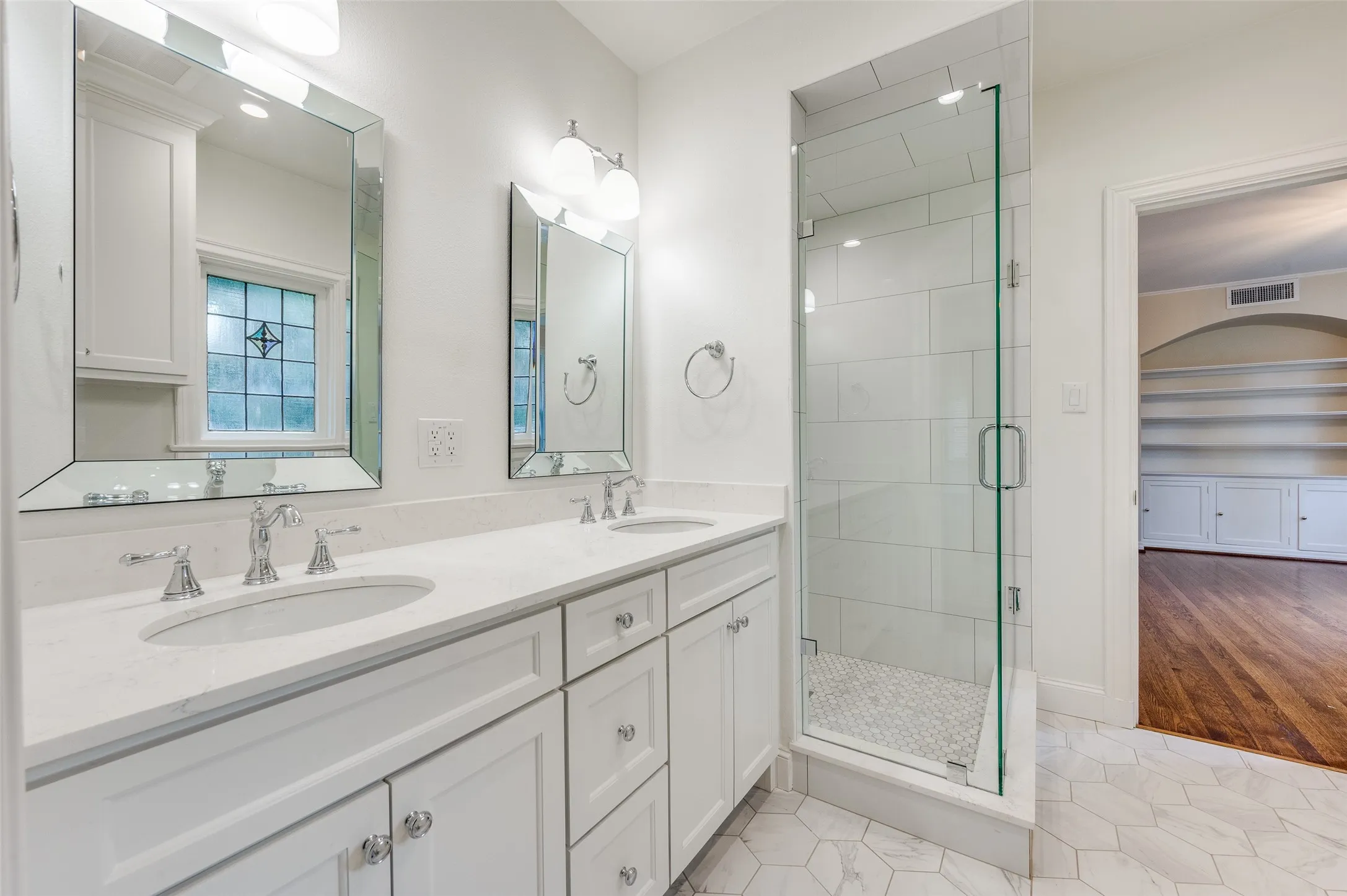 Primary bathroom featuring double vanity and large walk-in shower.