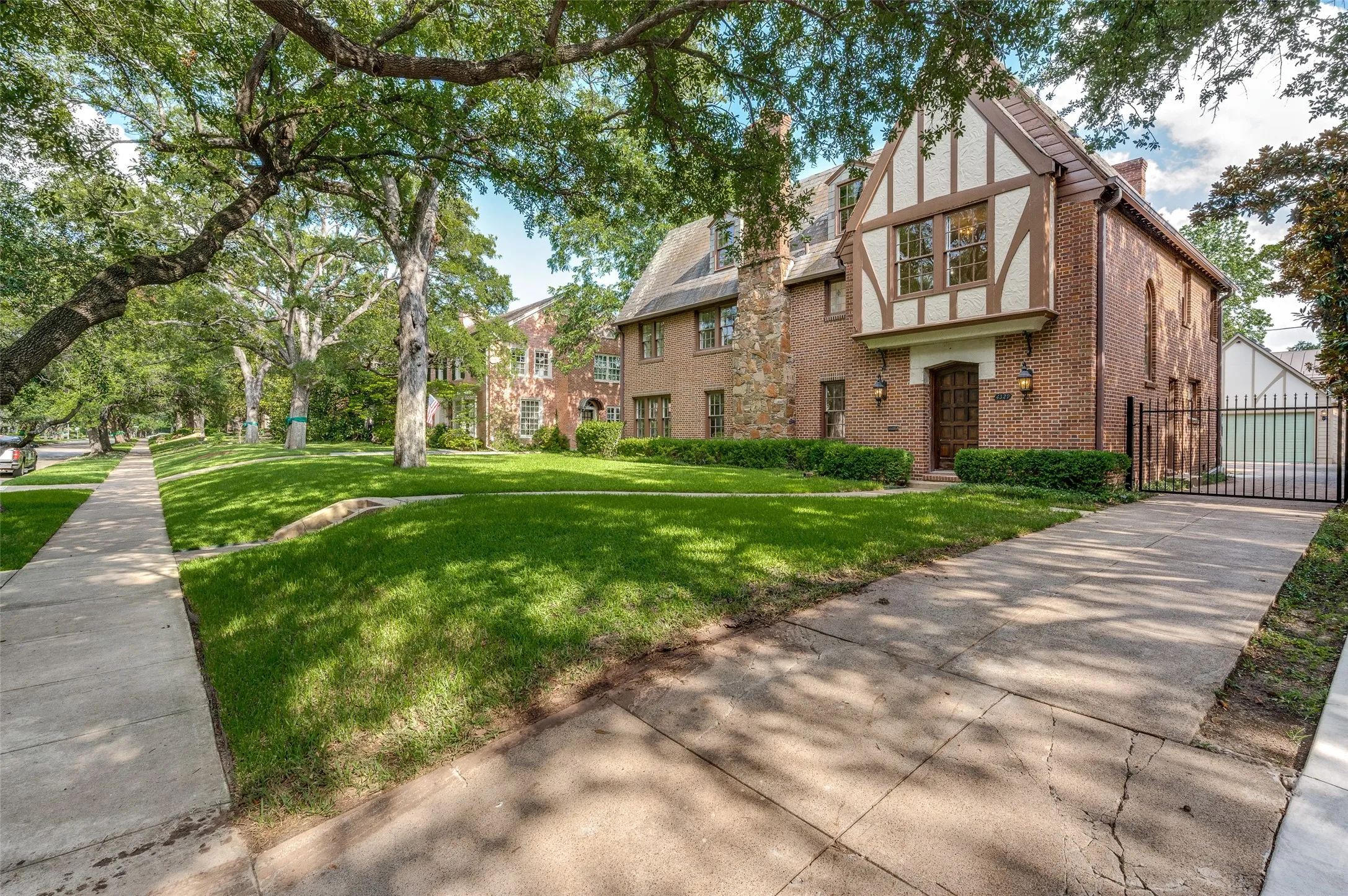 Tudor style home with charming facade and expansive front yard.