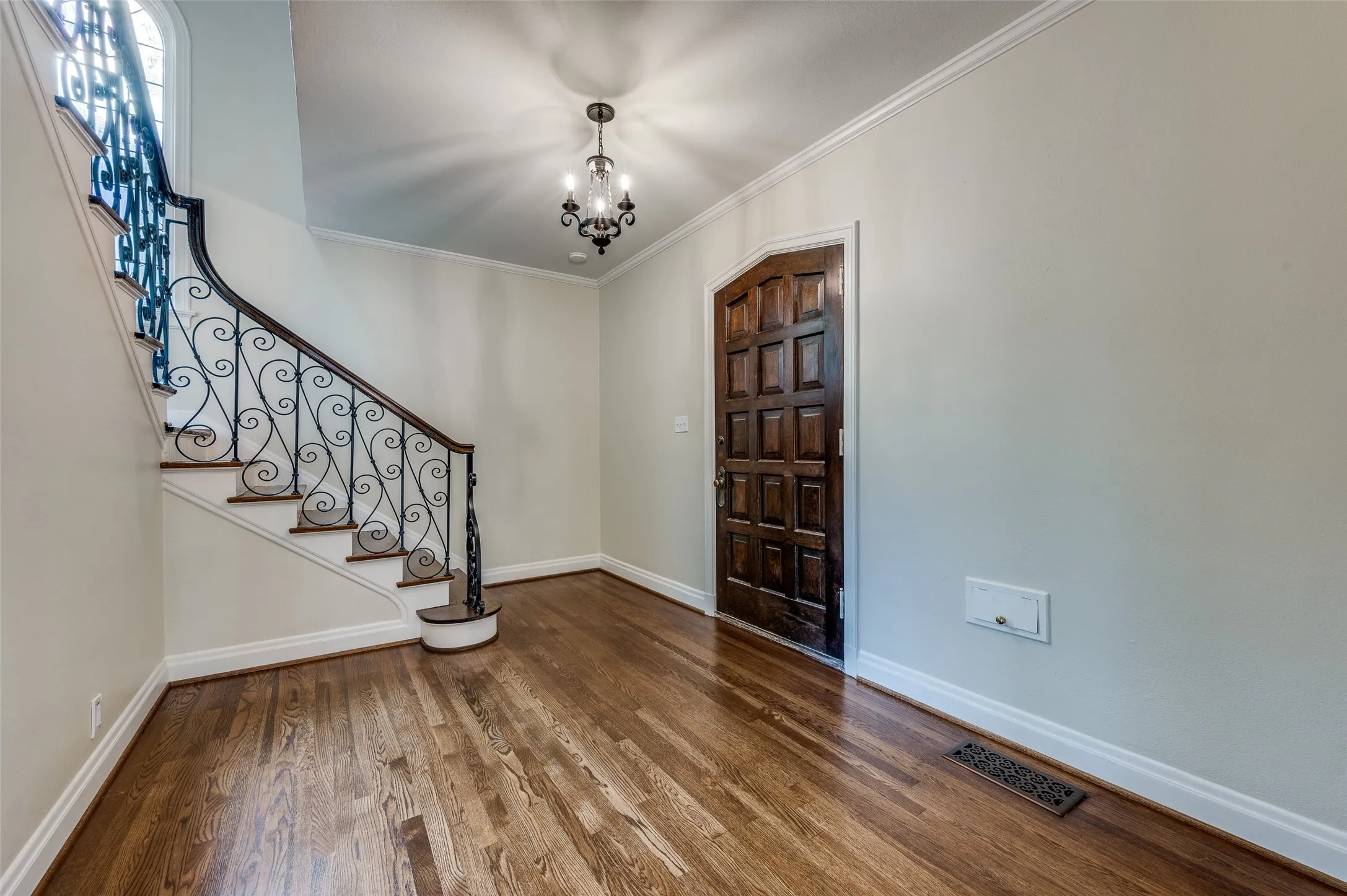 Welcoming foyer with chandelier and elegant split stairway.